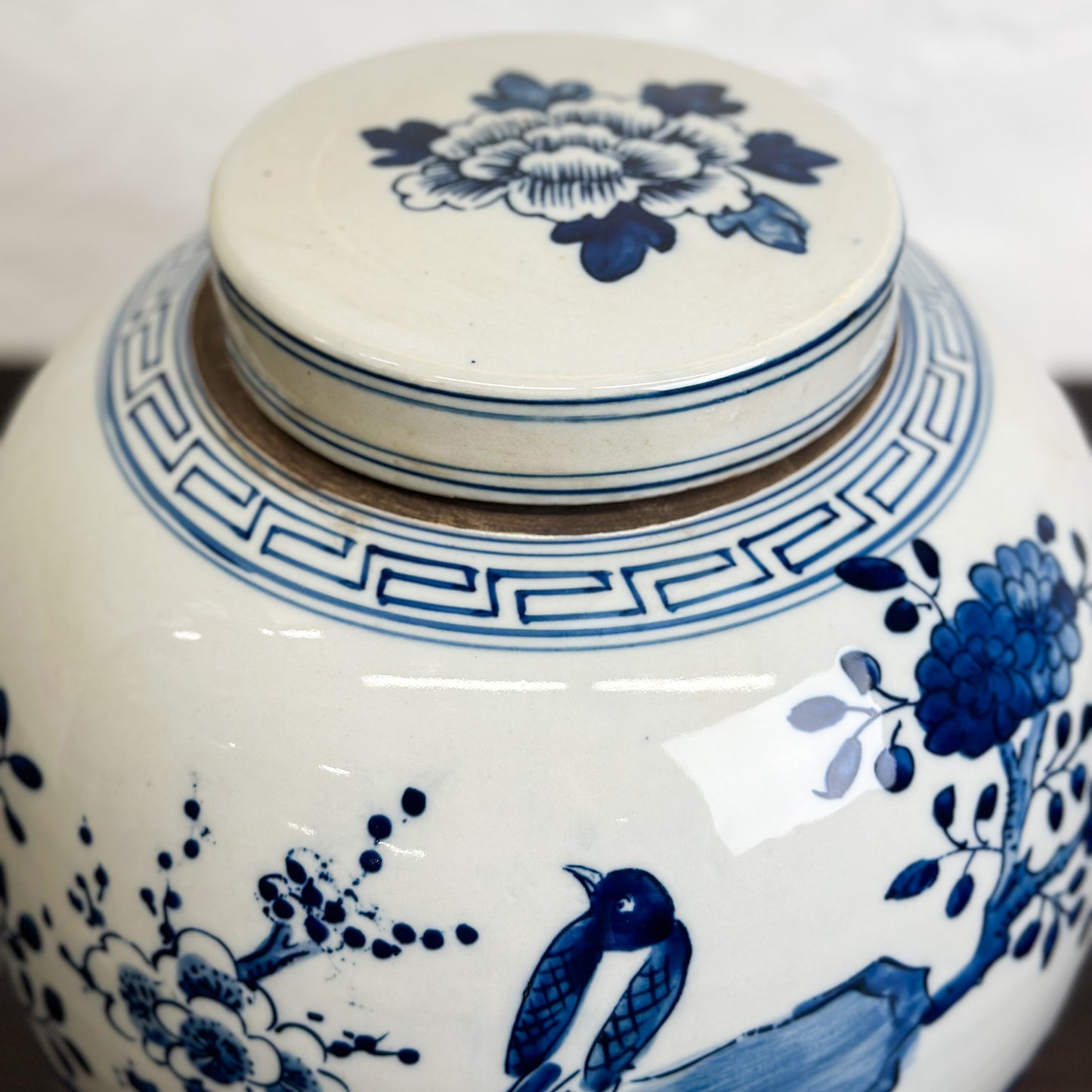 A porcelain ginger jar with blue and white floral patterns and a bird design.