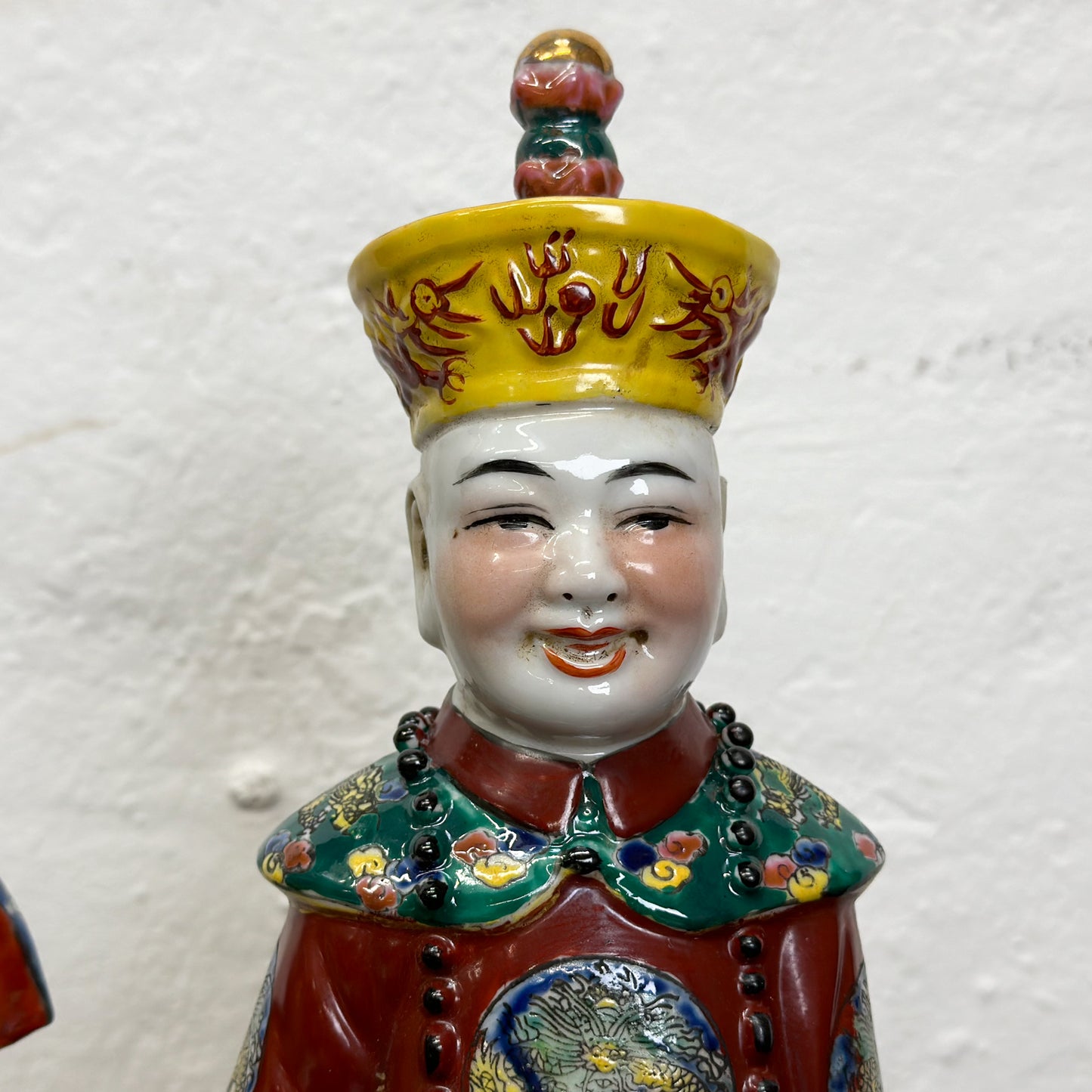 A set of three colored figurines representing Qing emperors, each in different attire, with decorative elements on their clothing and hats.