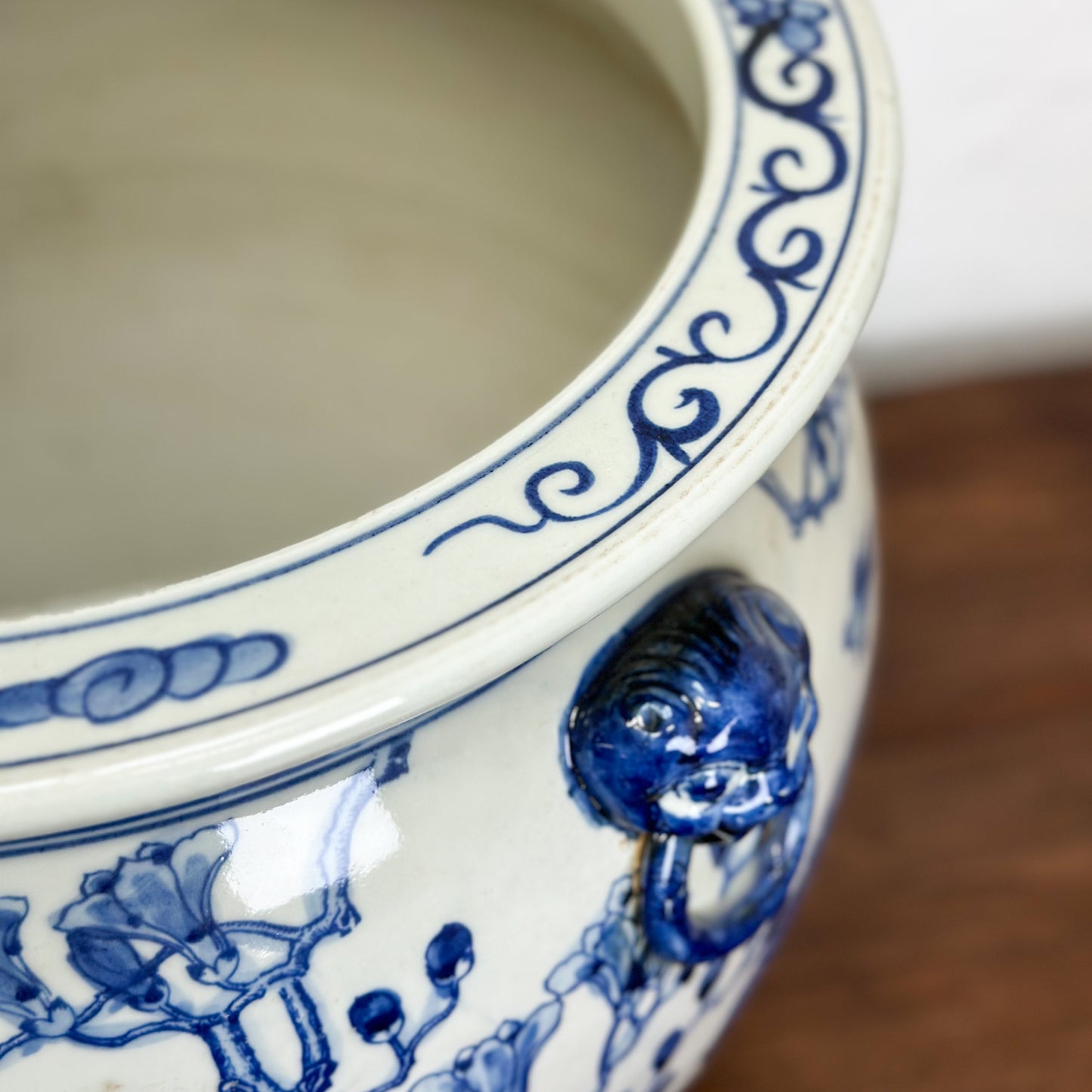 A porcelain planter with blue floral patterns and handles, displayed against a neutral background.