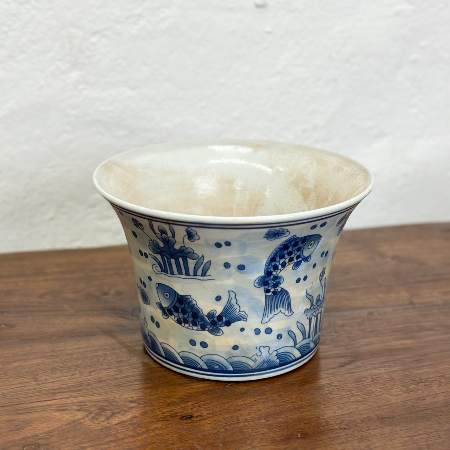 Two blue and white porcelain flared planters with fish patterns, displayed against a neutral background.