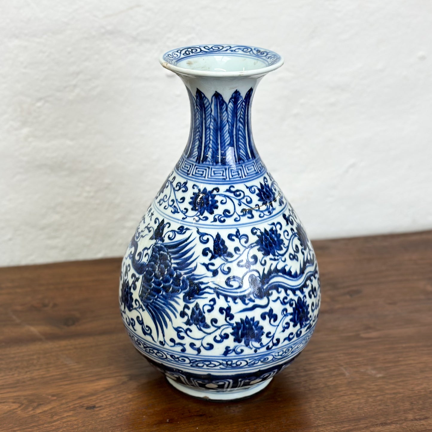 A blue and white porcelain vase with floral patterns, displayed against a neutral background.