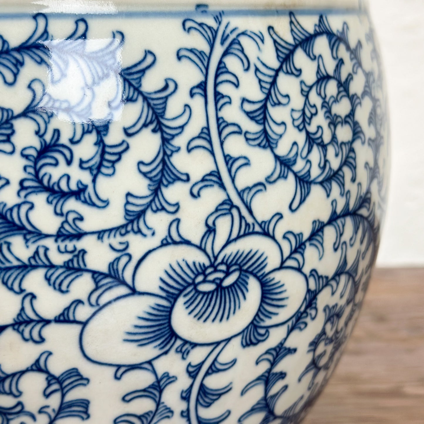 A round porcelain planter with a floral pattern in blue and white colors.