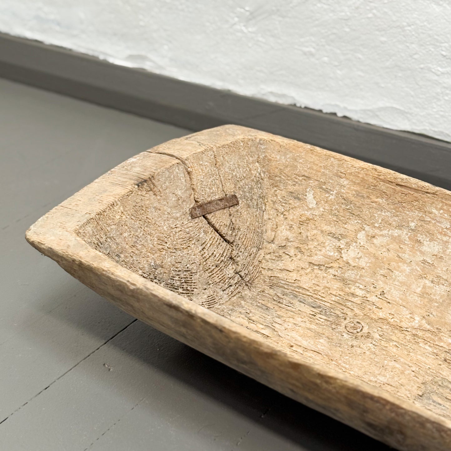 Wooden cutting board on a gray floor