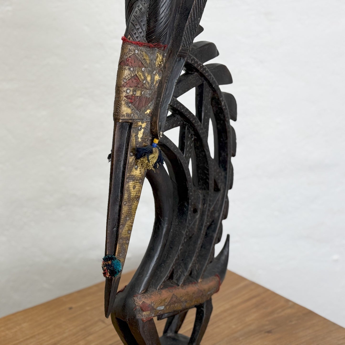 A sculpture of a mythical creature with a metal structure having a mix of dark and light brown colors, standing upright against a plain background.