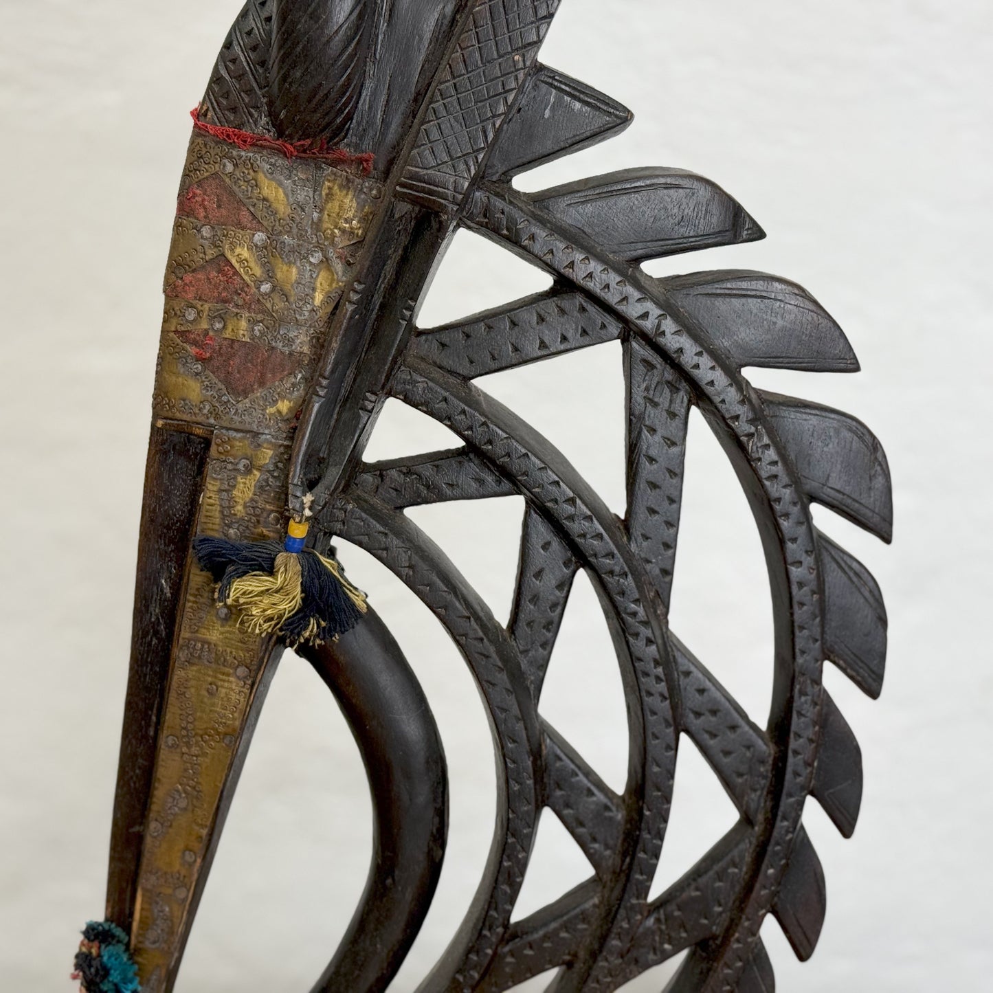A sculpture of a mythical creature with a metal structure having a mix of dark and light brown colors, standing upright against a plain background.