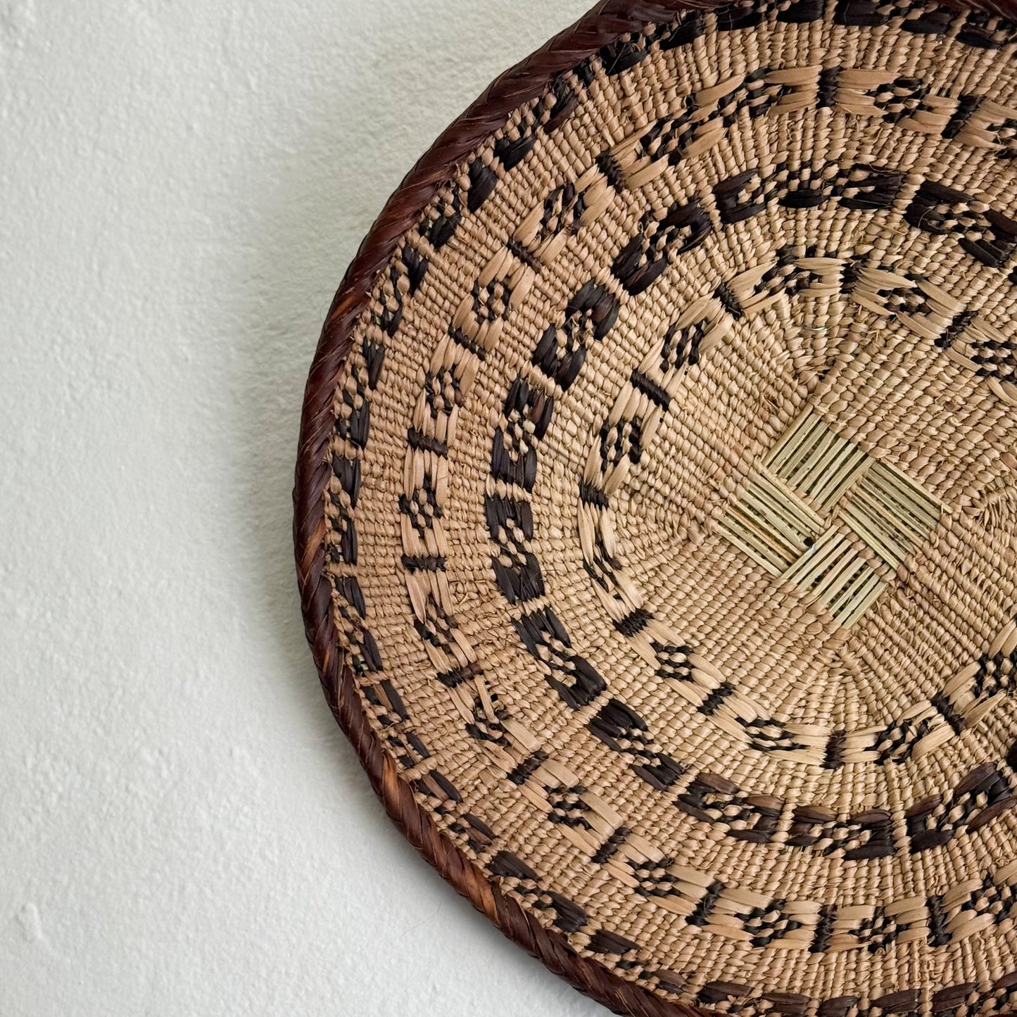 Woven basket with intricate patterns on a white background