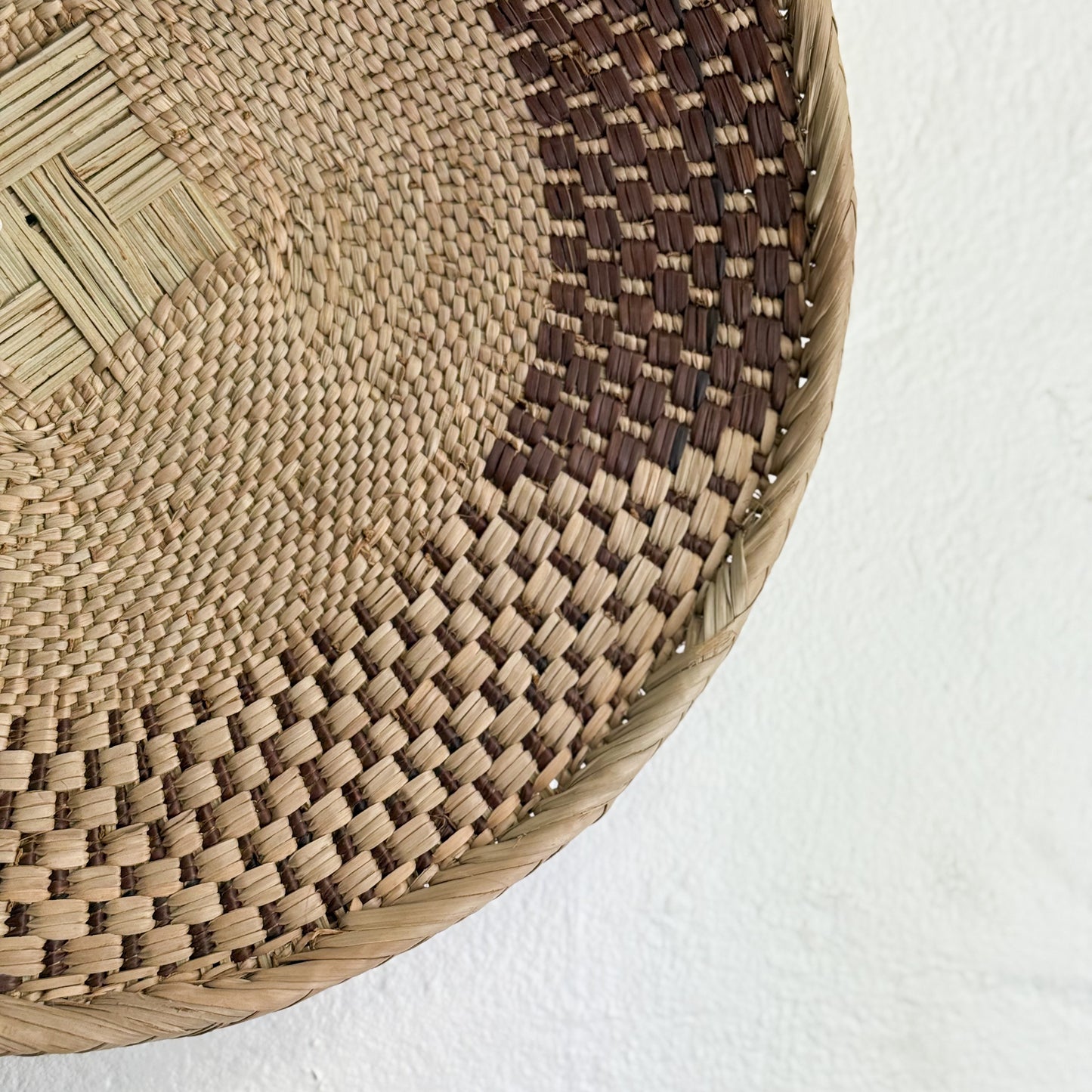 Close-up of a woven basket with a textured pattern on a white background