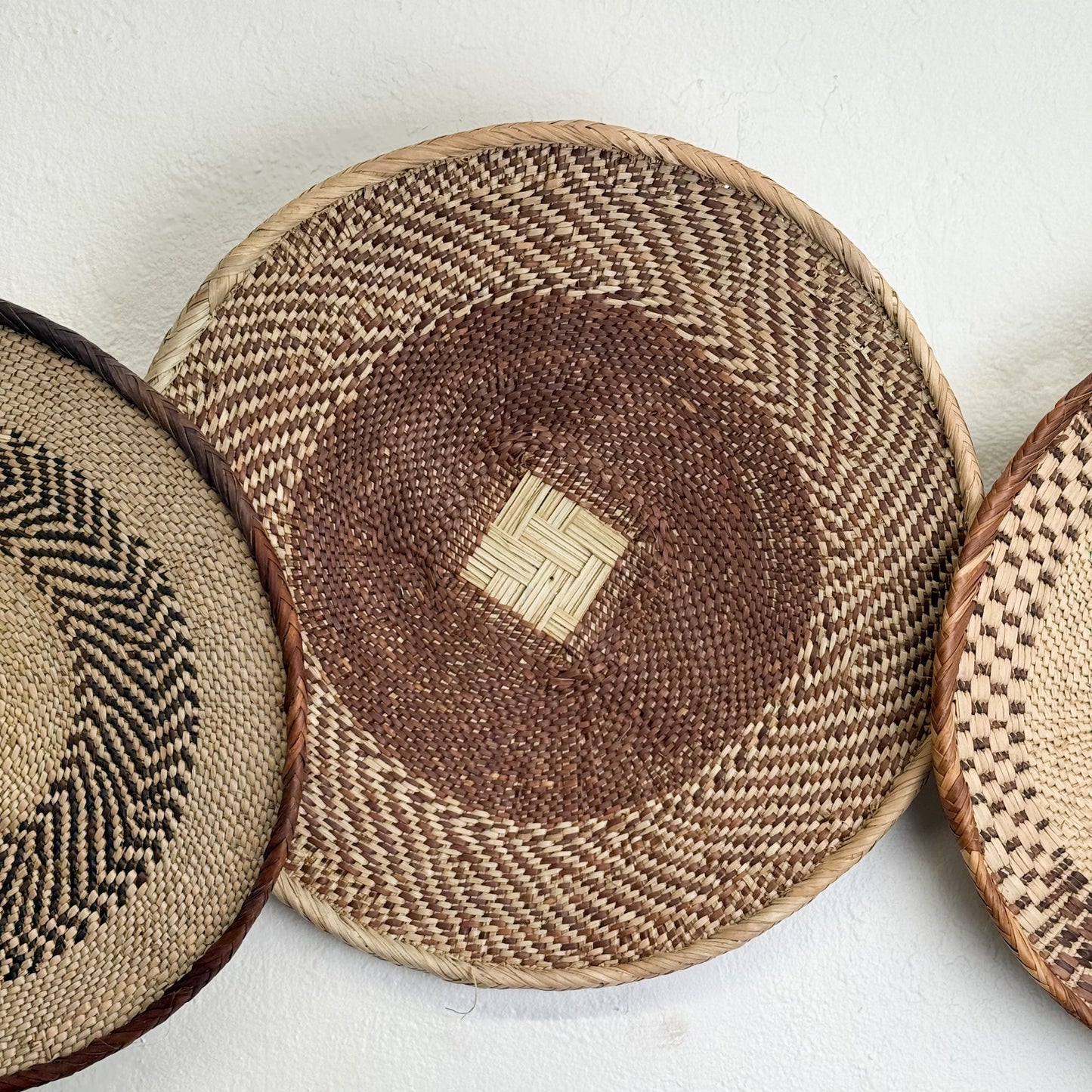 Three woven coasters with different patterns on a white background