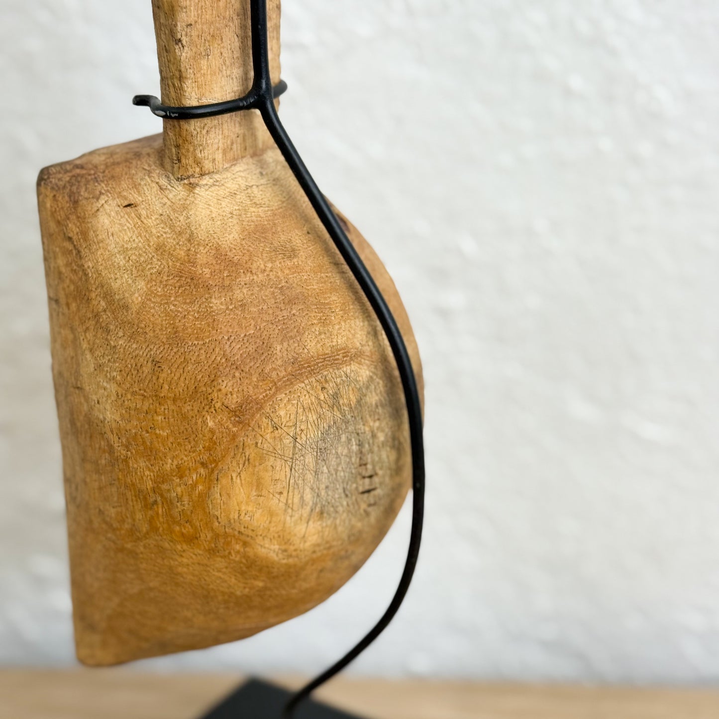 Wooden tool with a black cord against a white background