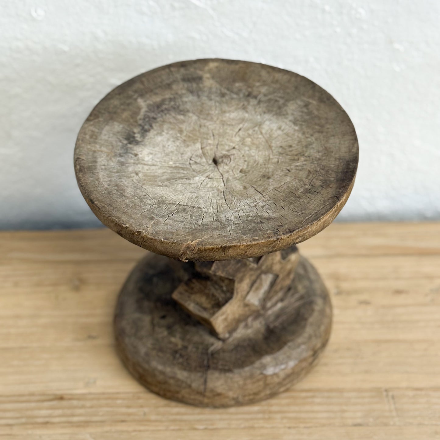 Wooden spindle on a wooden surface with a white background