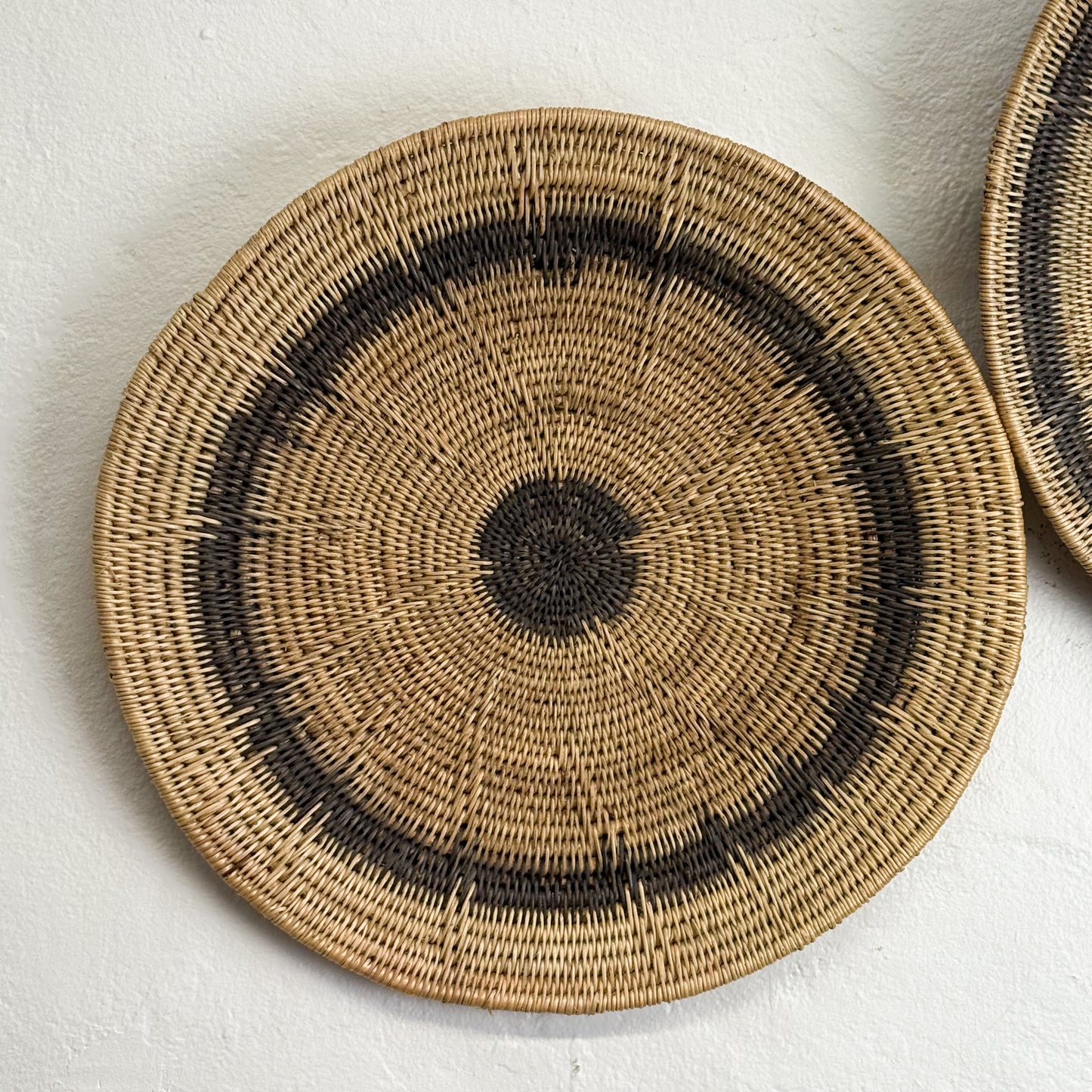 Woven basket with concentric circle pattern on a light background