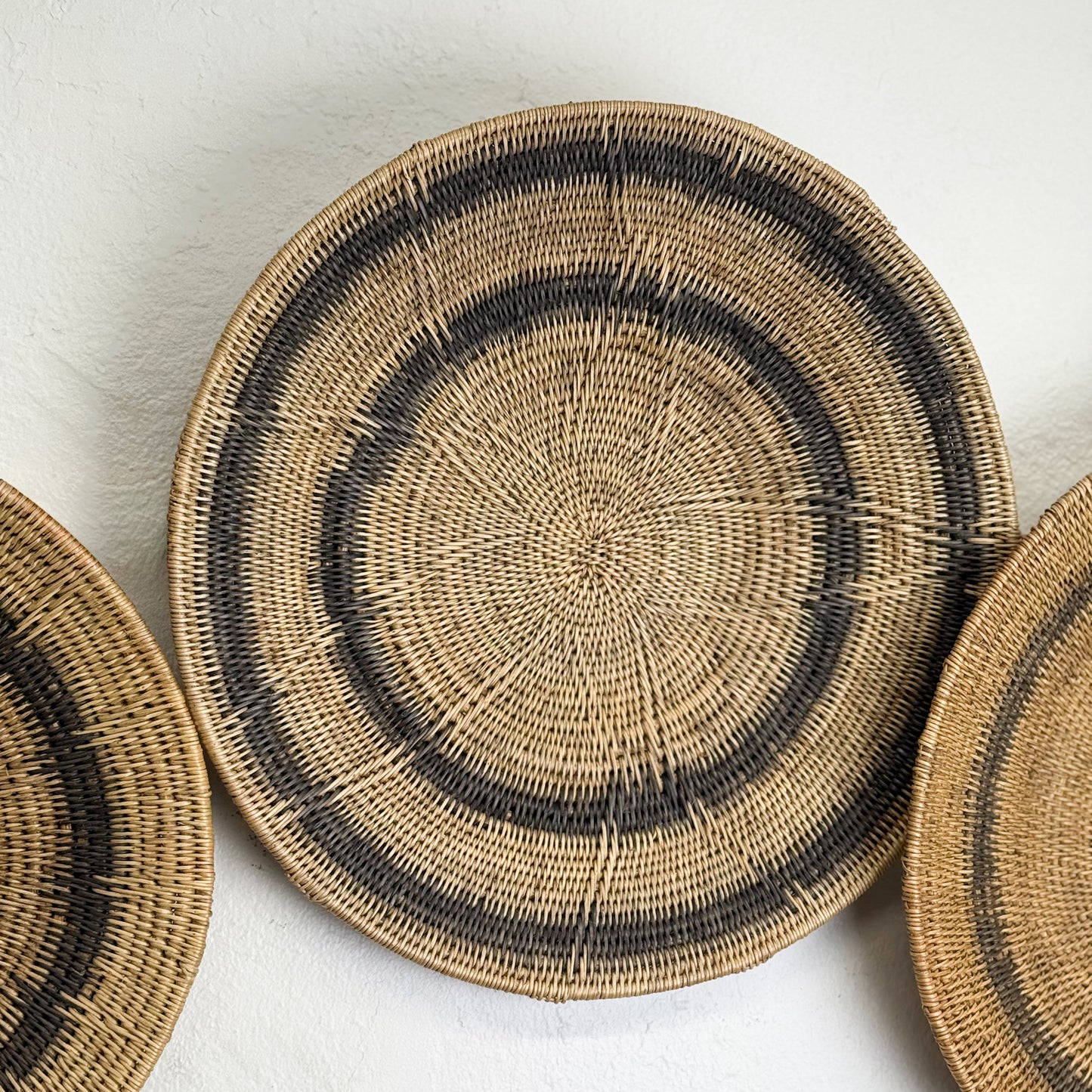 Woven baskets with black patterns on a white background