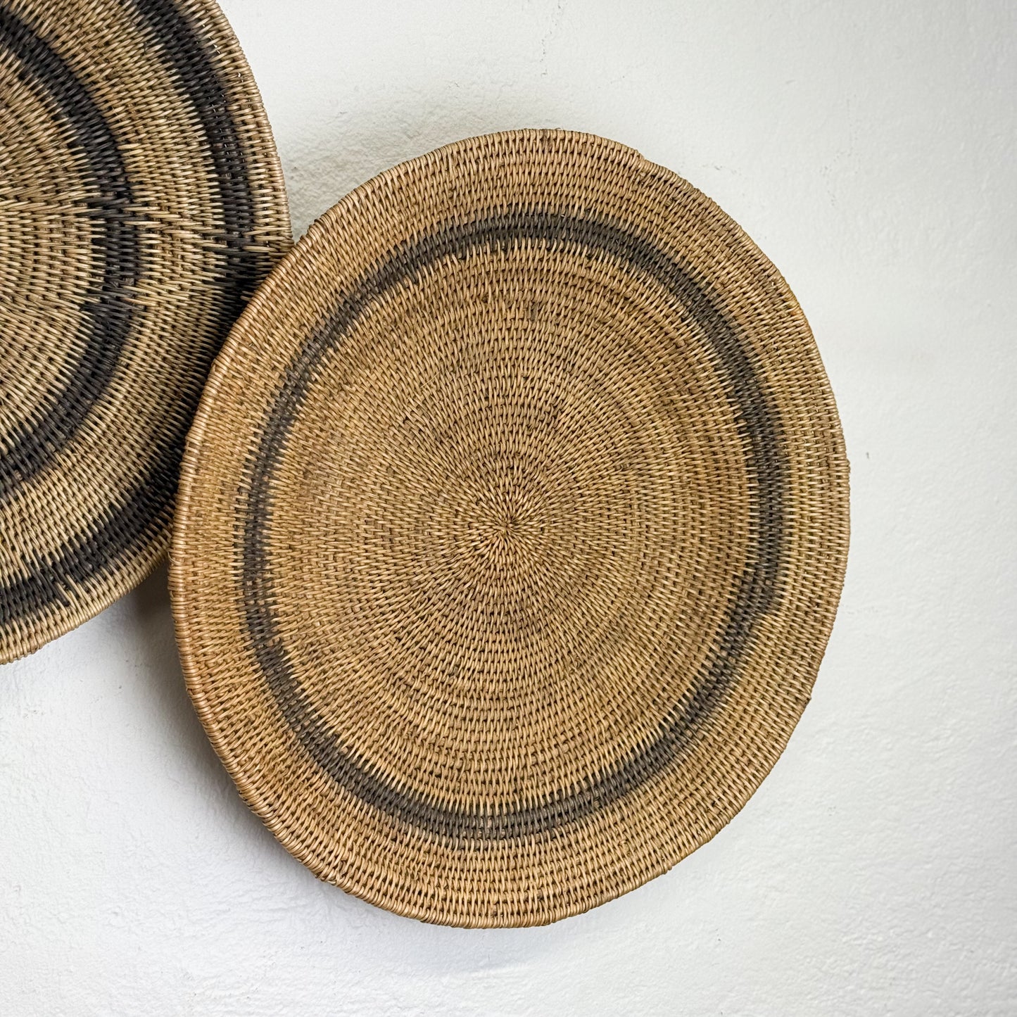 Two woven baskets on a light gray background