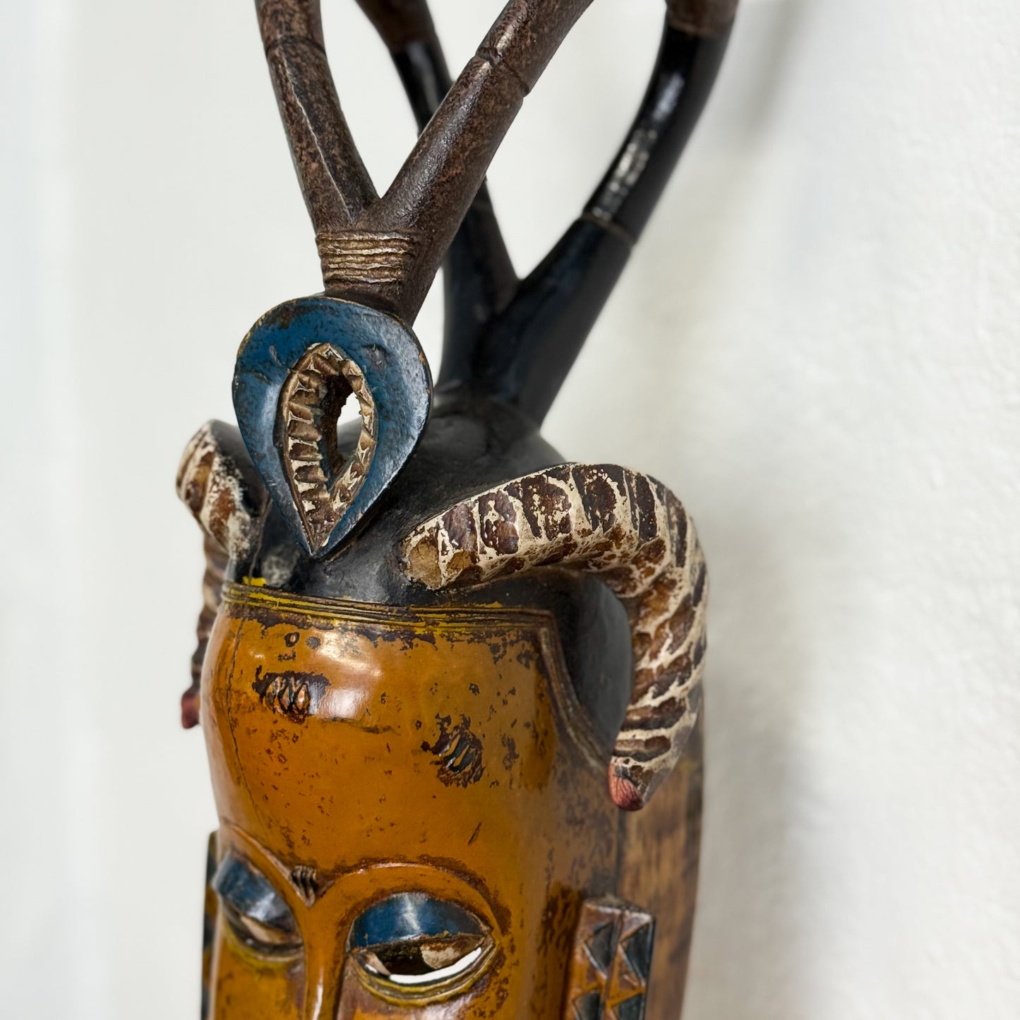 Decorative mask with snake and eye design on a white background