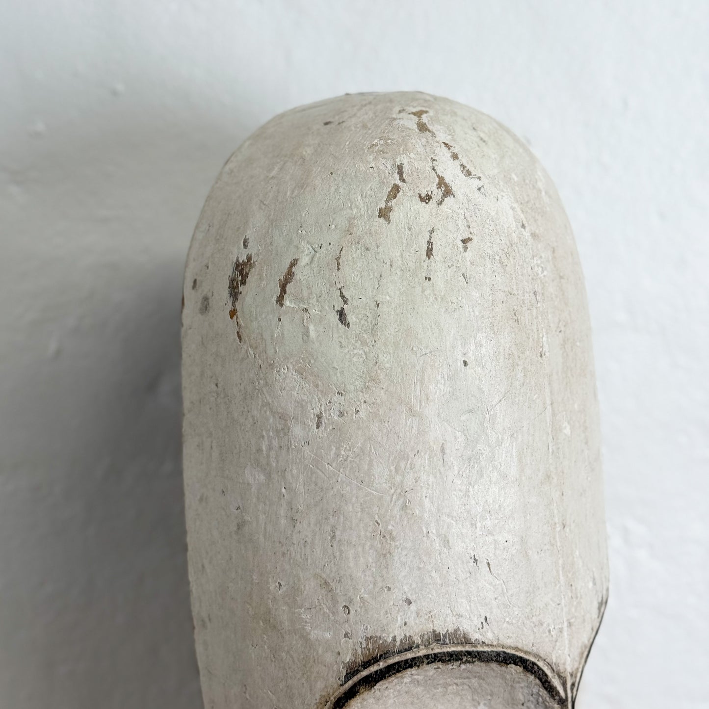 Close-up of a worn-out white valve handle on a light gray background