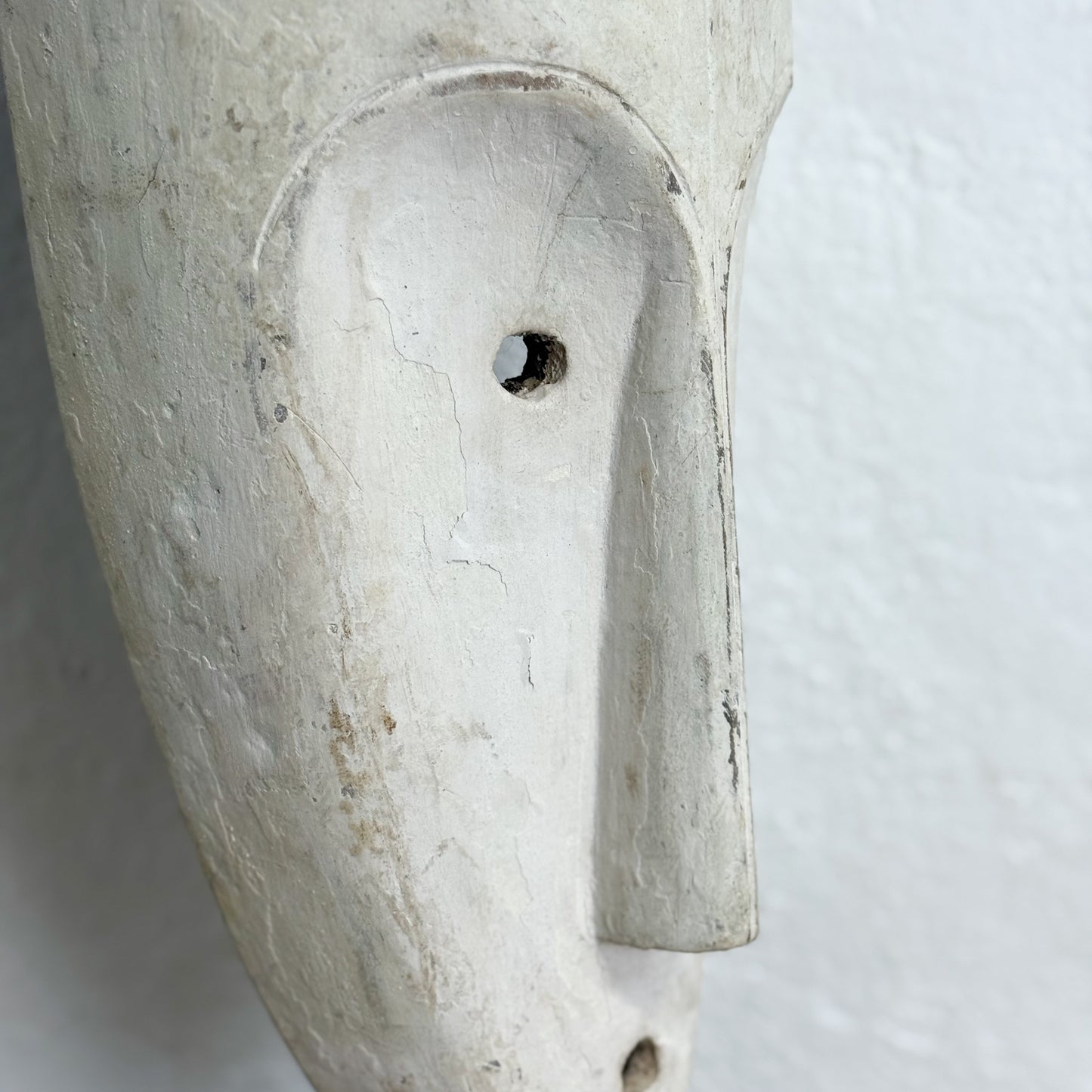 Close-up of a stone sculpture resembling a face on a white background