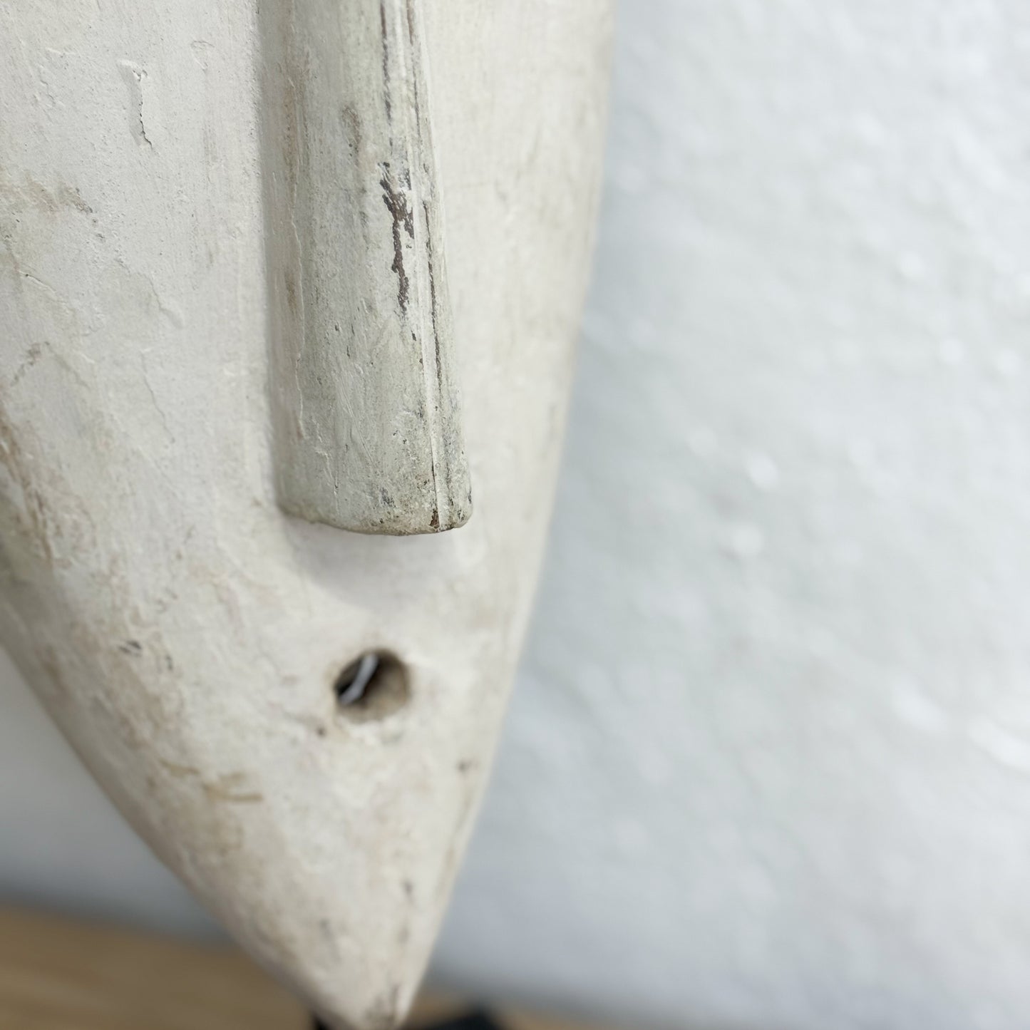 Close-up of a stone tool with a cylindrical handle on a white background