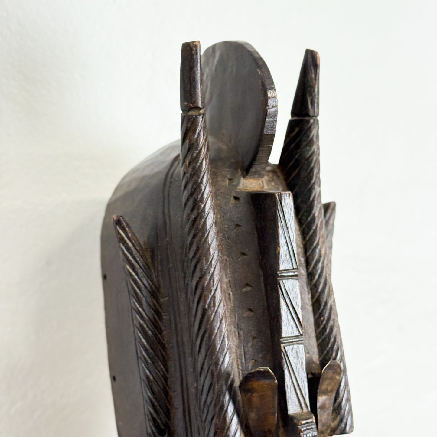 Wooden mask with intricate carvings on a white background