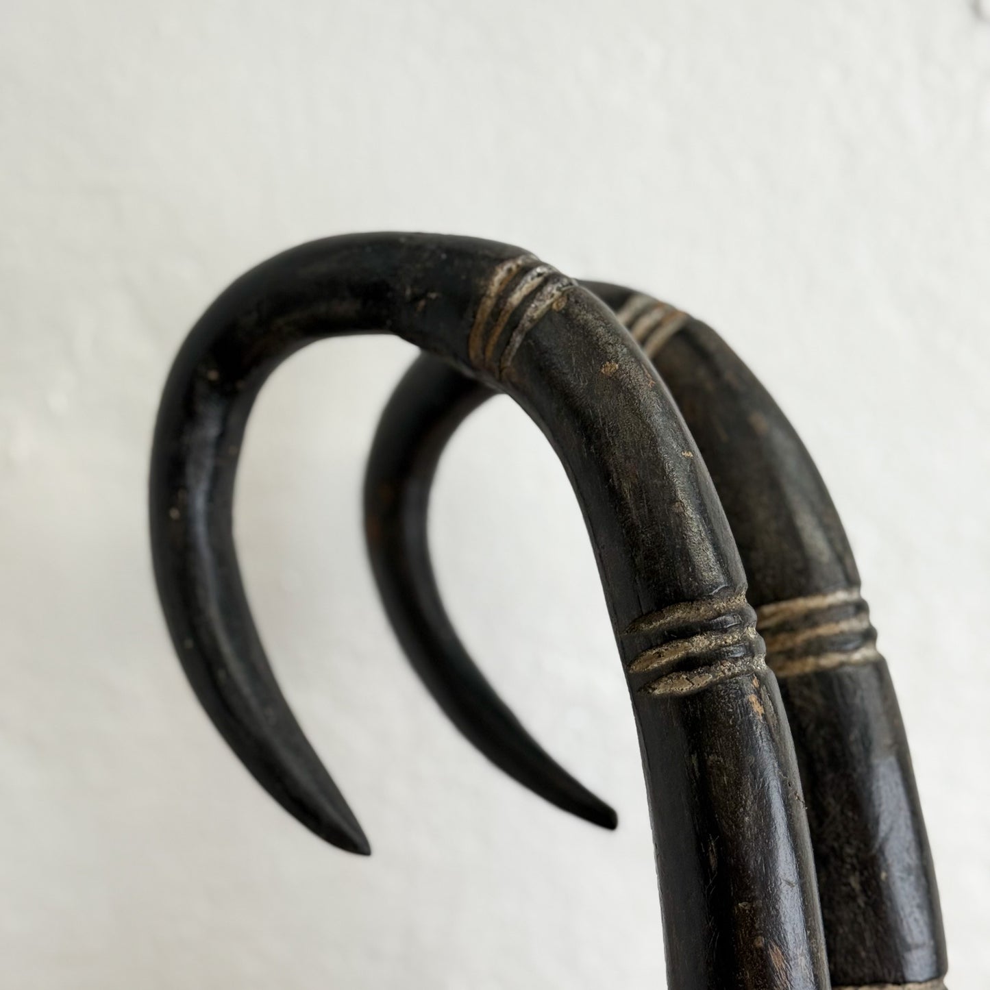 Black curved object with decorative elements on a light gray background