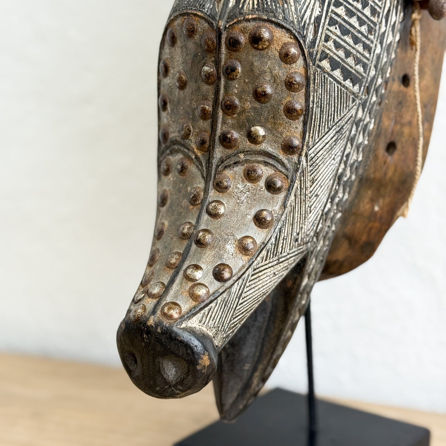 Decorative metal mask with intricate patterns on a white background