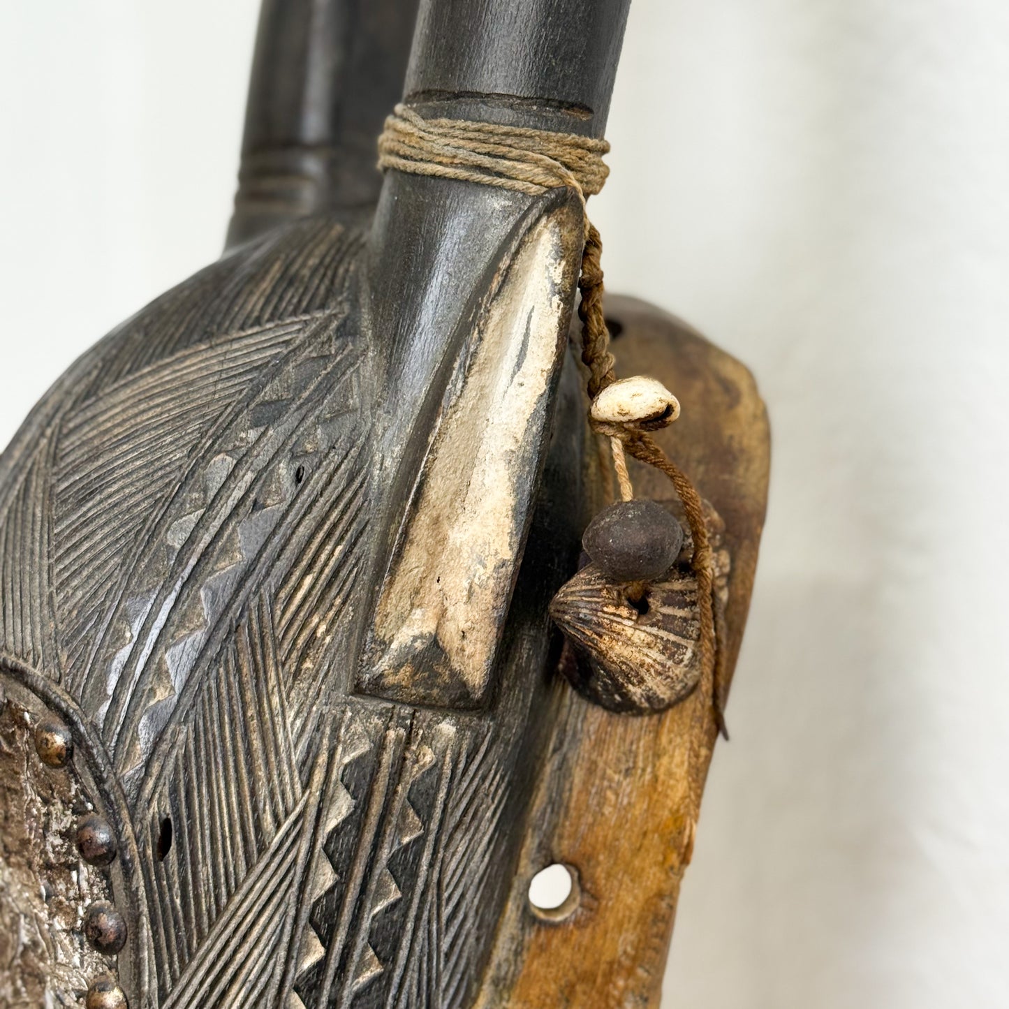Close-up of a wooden and metal object with intricate carvings and textures.