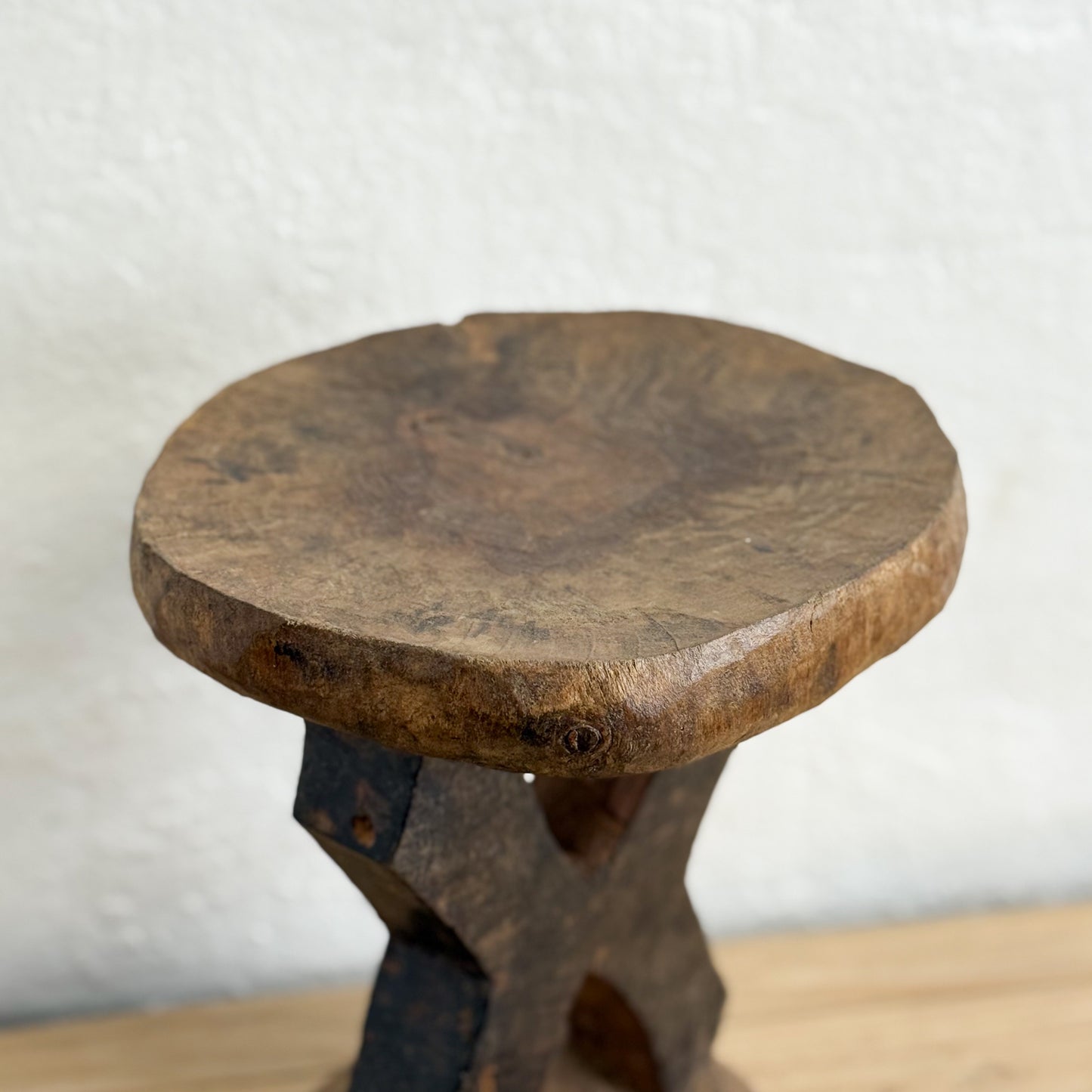 Wooden stool with a rustic design on a neutral background