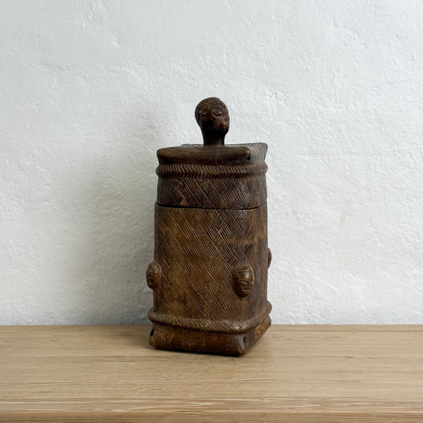 Wooden container with lid on a wooden surface and white background