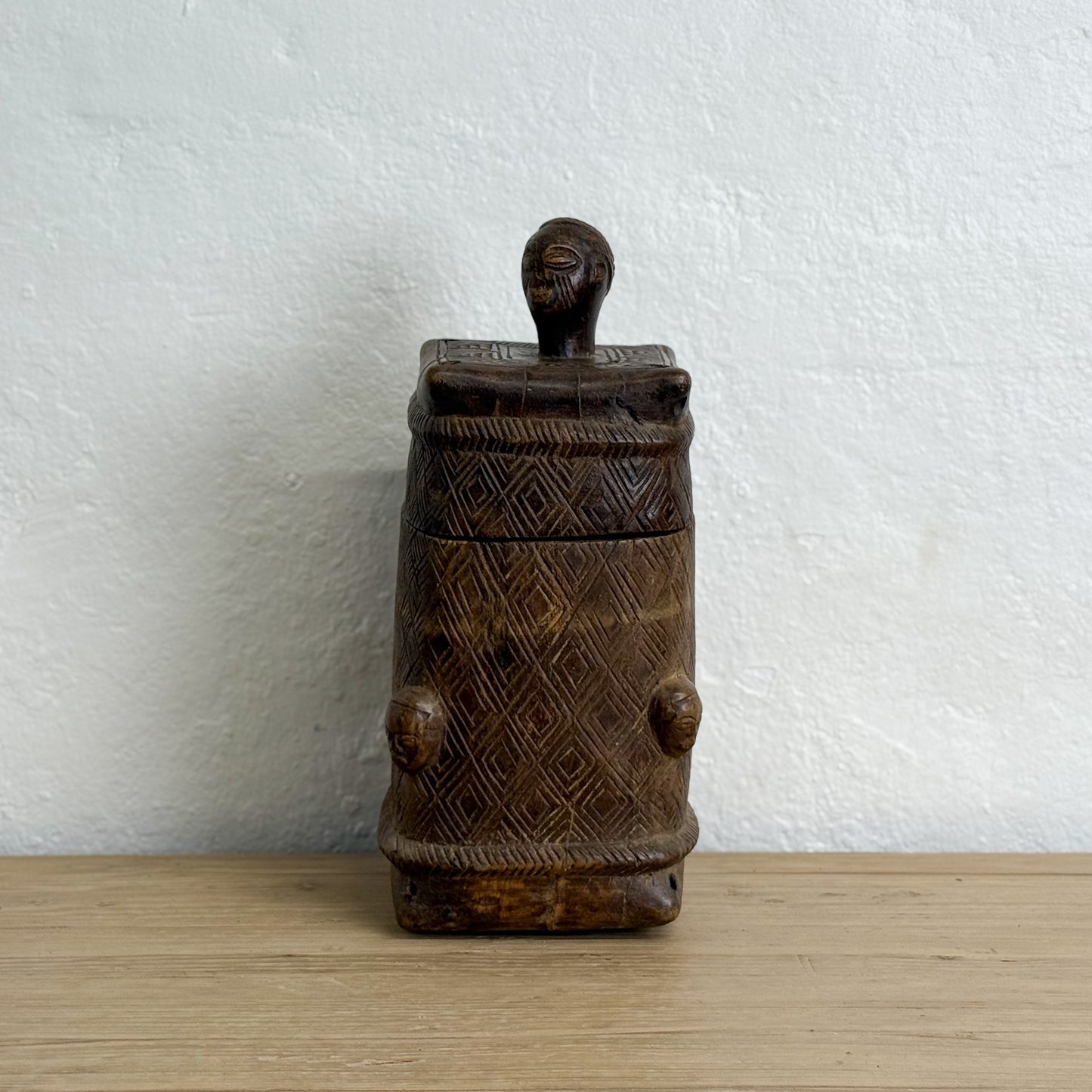 Wooden container with geometric patterns on a white background