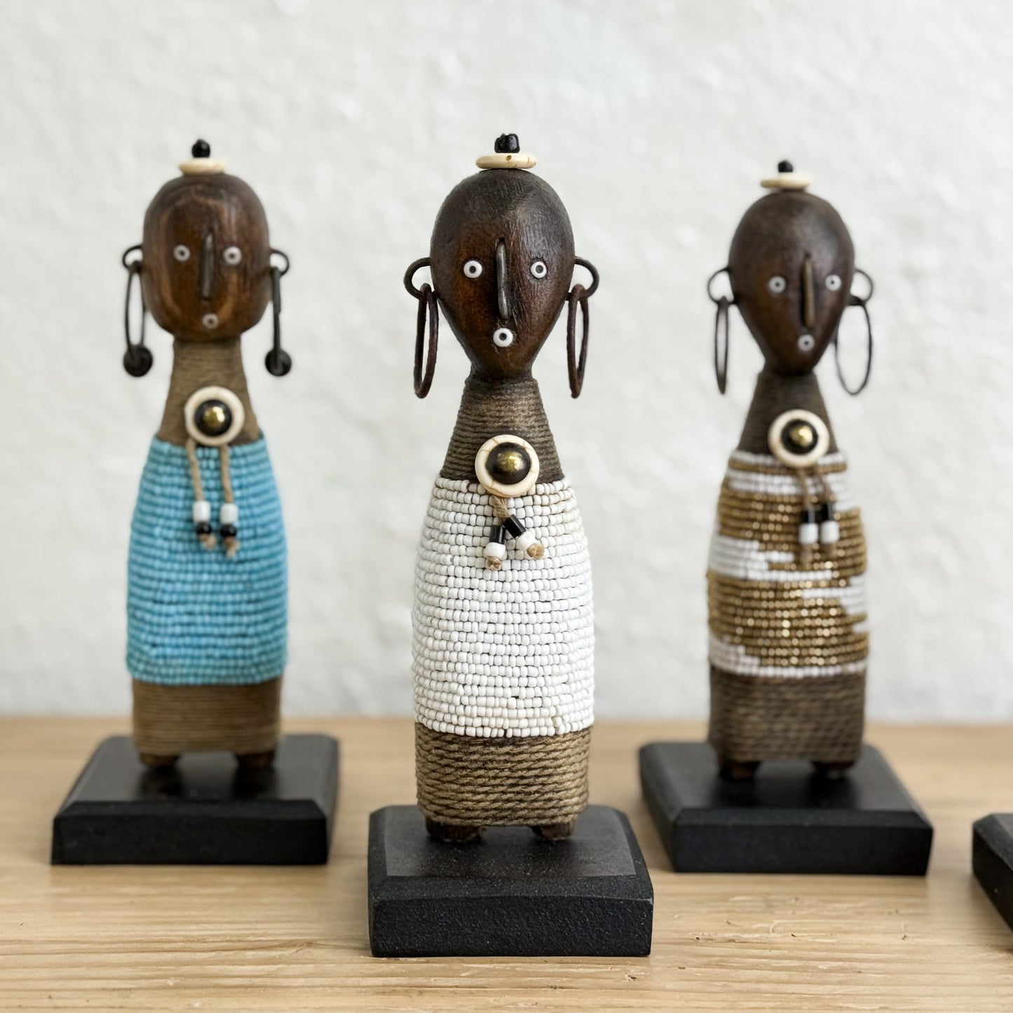 Three decorative figurines with unique designs on a wooden surface.