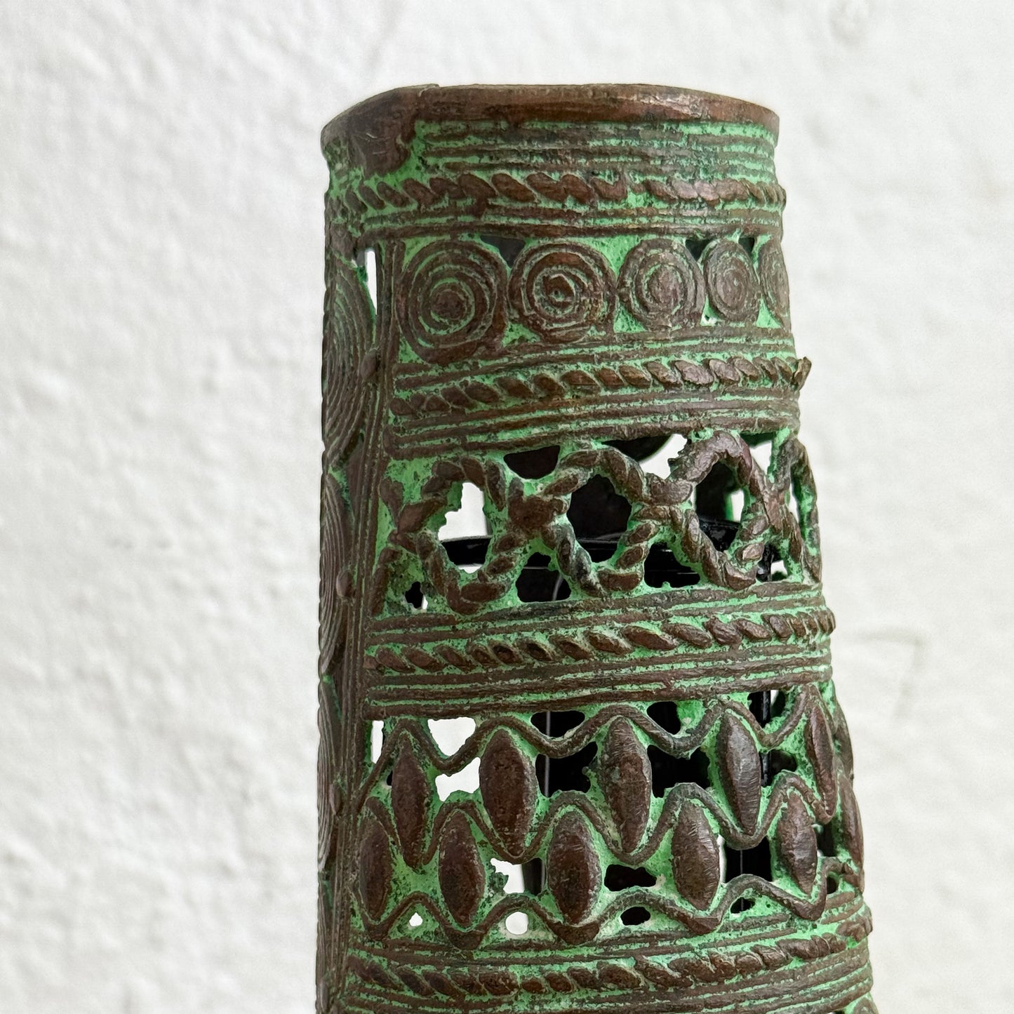 Decorative ceramic vase with intricate patterns on a textured white background