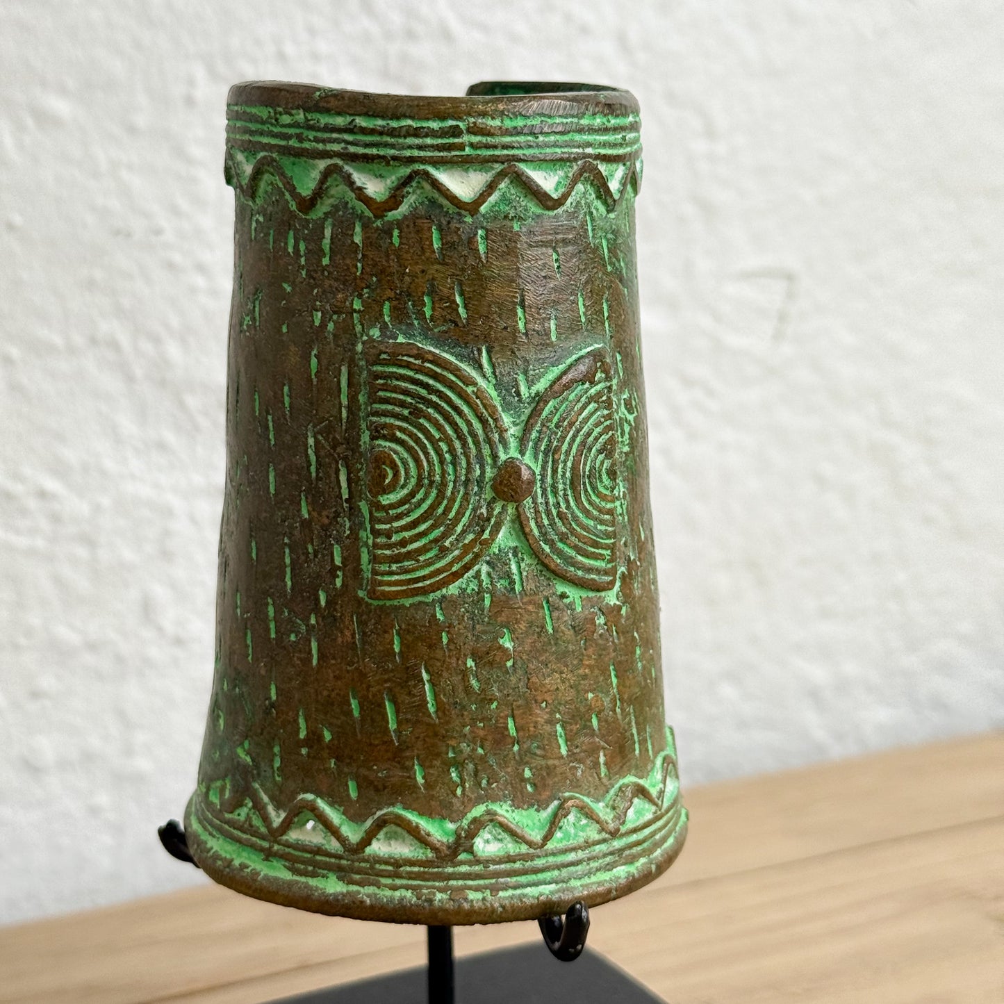 Decorative ceramic bell with green glaze on a white background