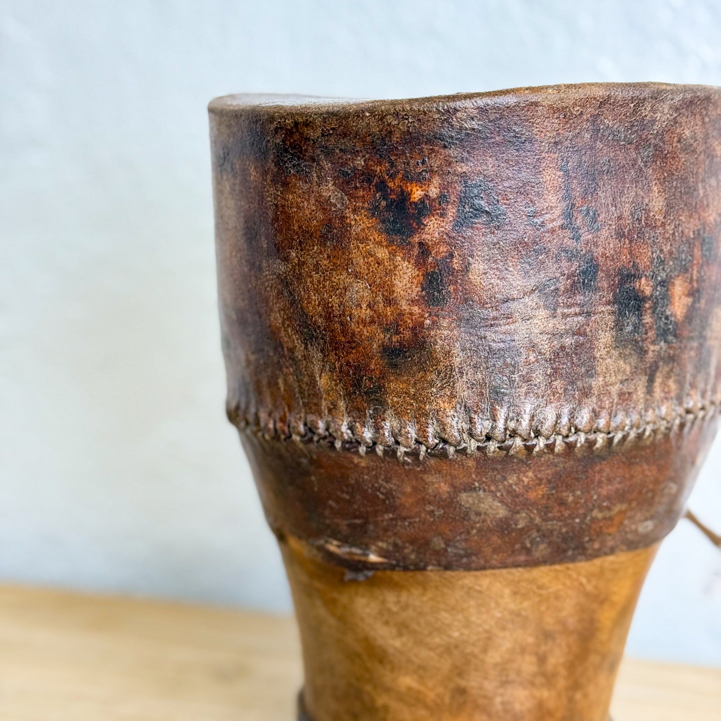 Close-up of a worn wooden drum with a light blue background