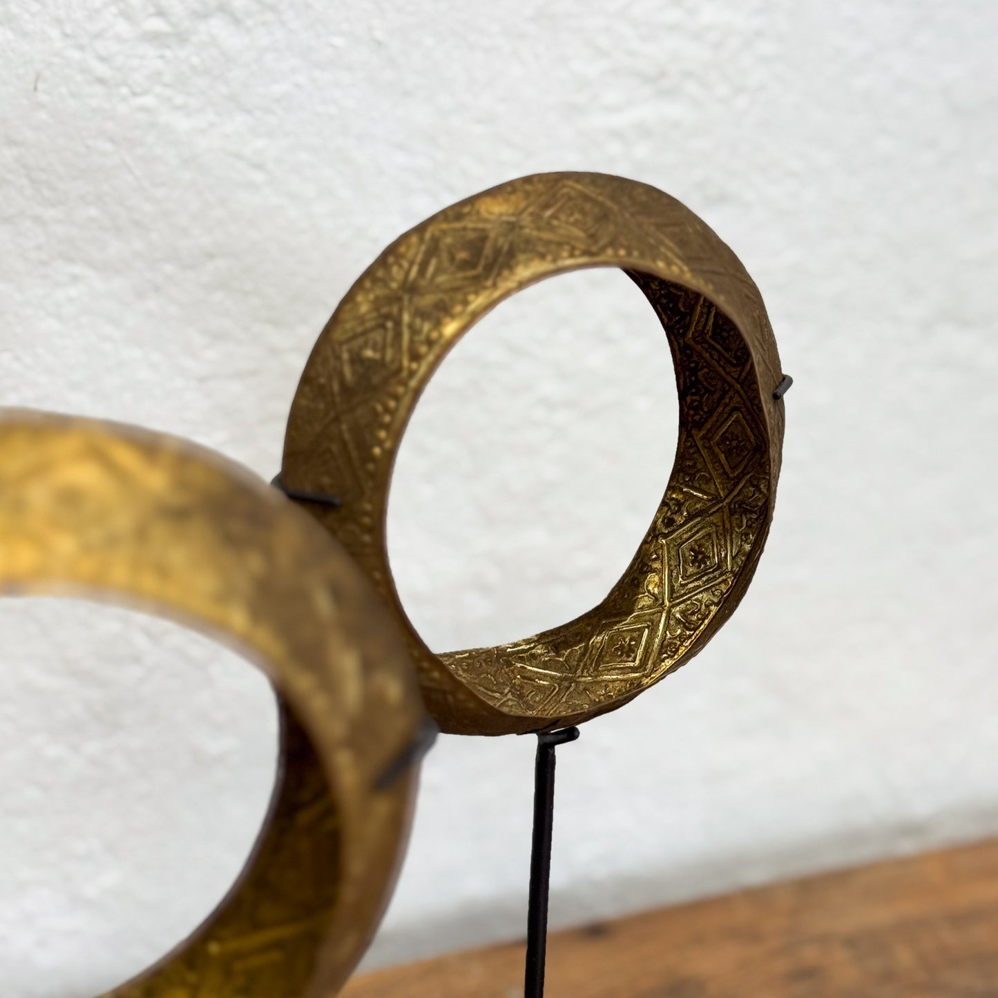 Pair of ornate gold hoop earrings on a white background