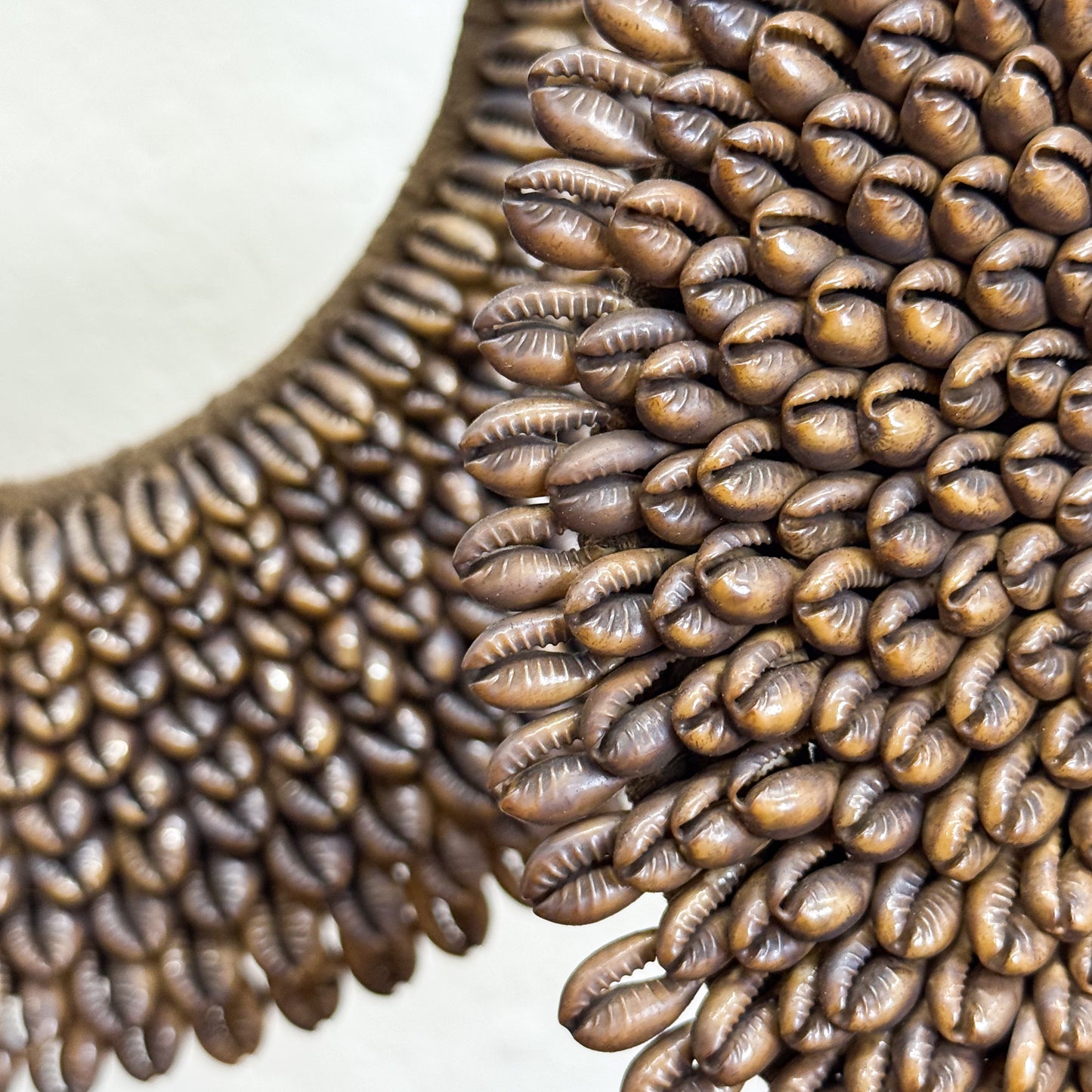 Close-up of a decorative necklace with shell-like patterns on a white background