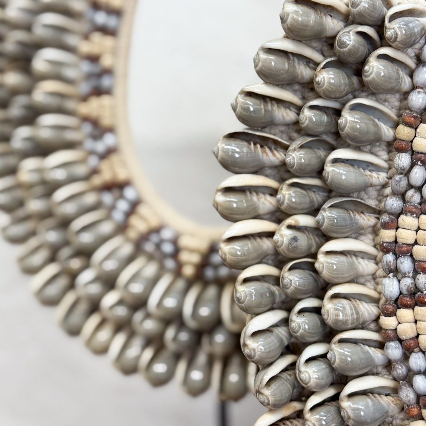Close-up of a shell and bead necklace on a white background