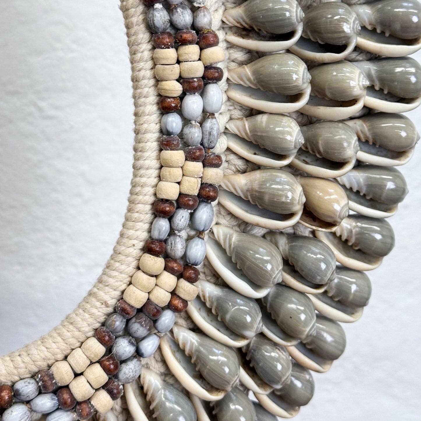 Decorative item with shell and bead pattern on a white background