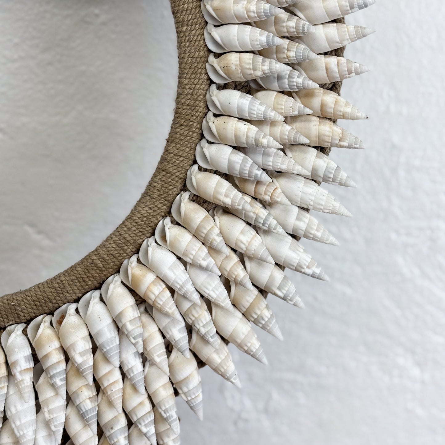 Decorative wreath made of shell-like material on a neutral background
