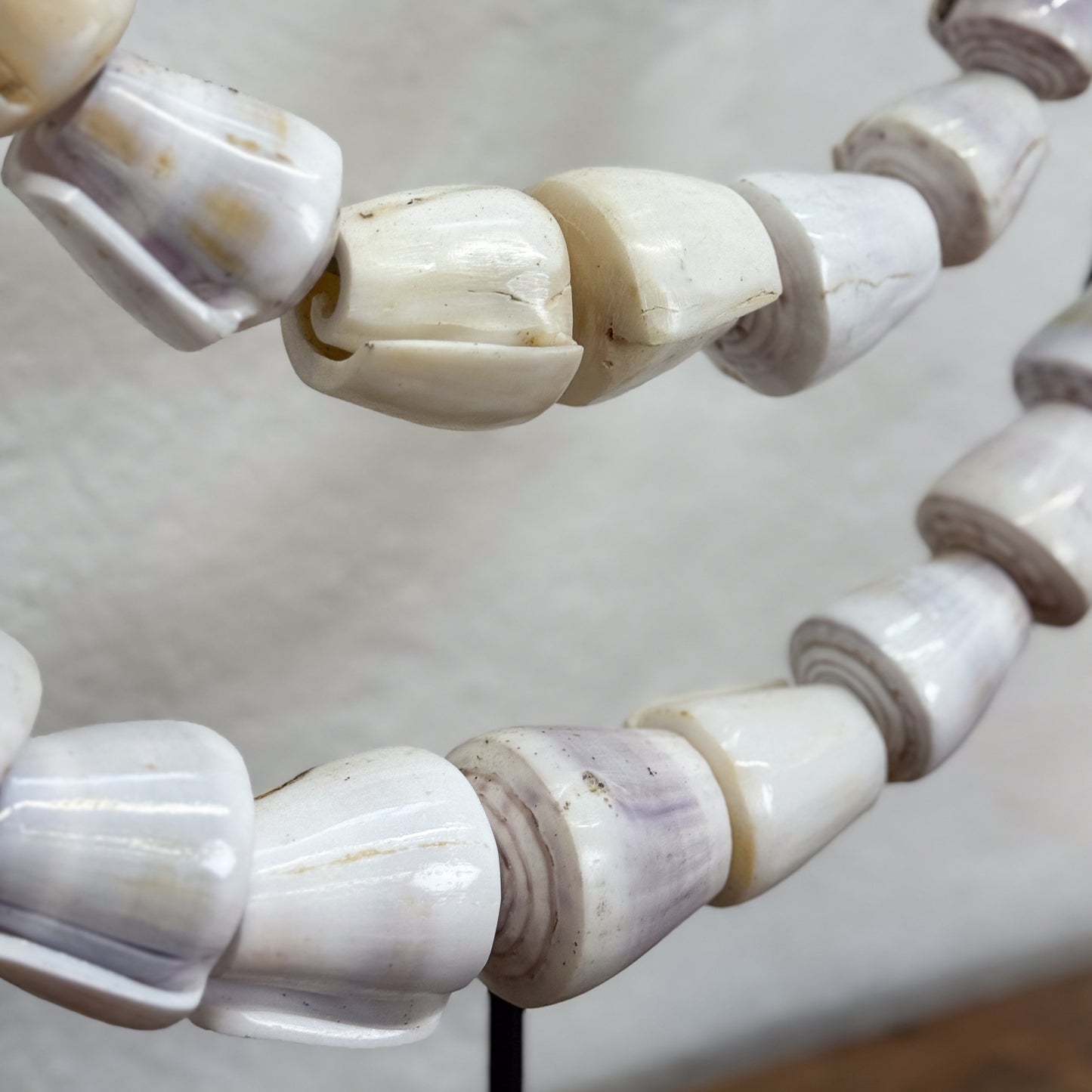 Close-up of a bracelet with white beaded design on a neutral background