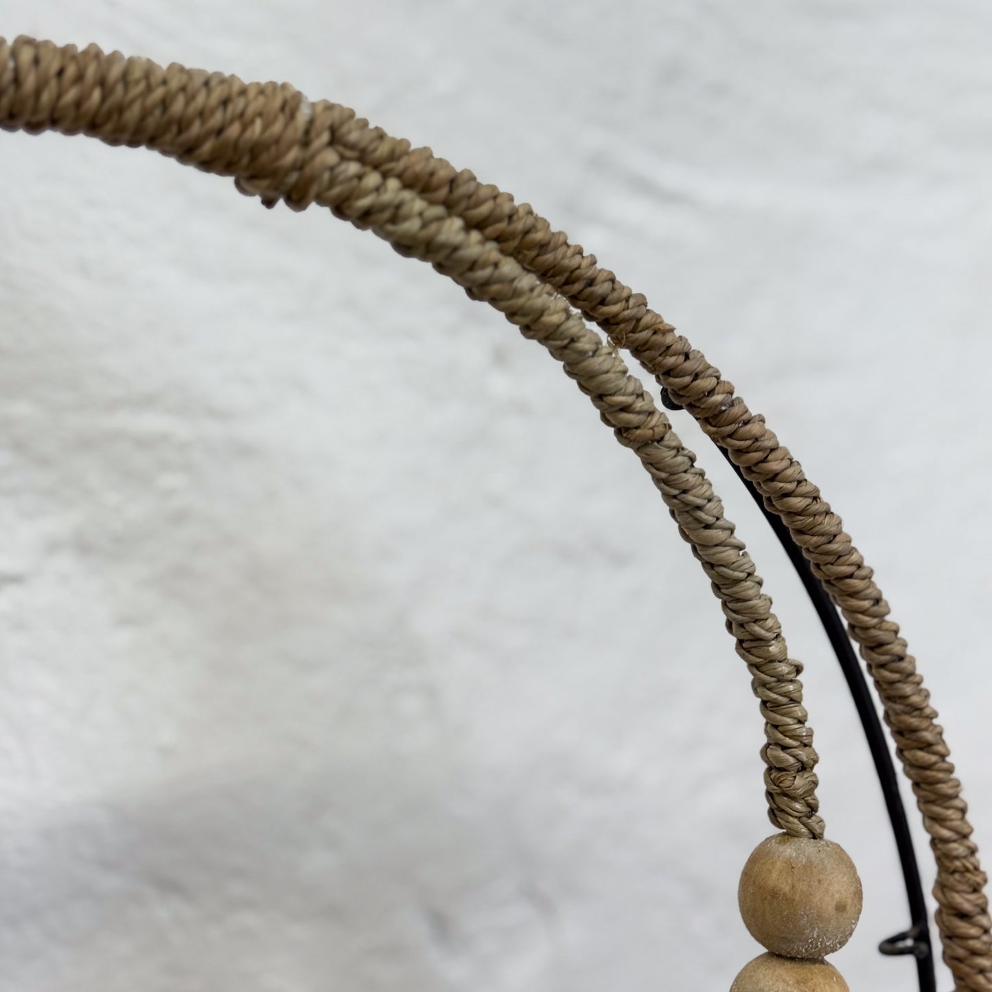 Close-up of a woven headband with a stone bead on a light gray background