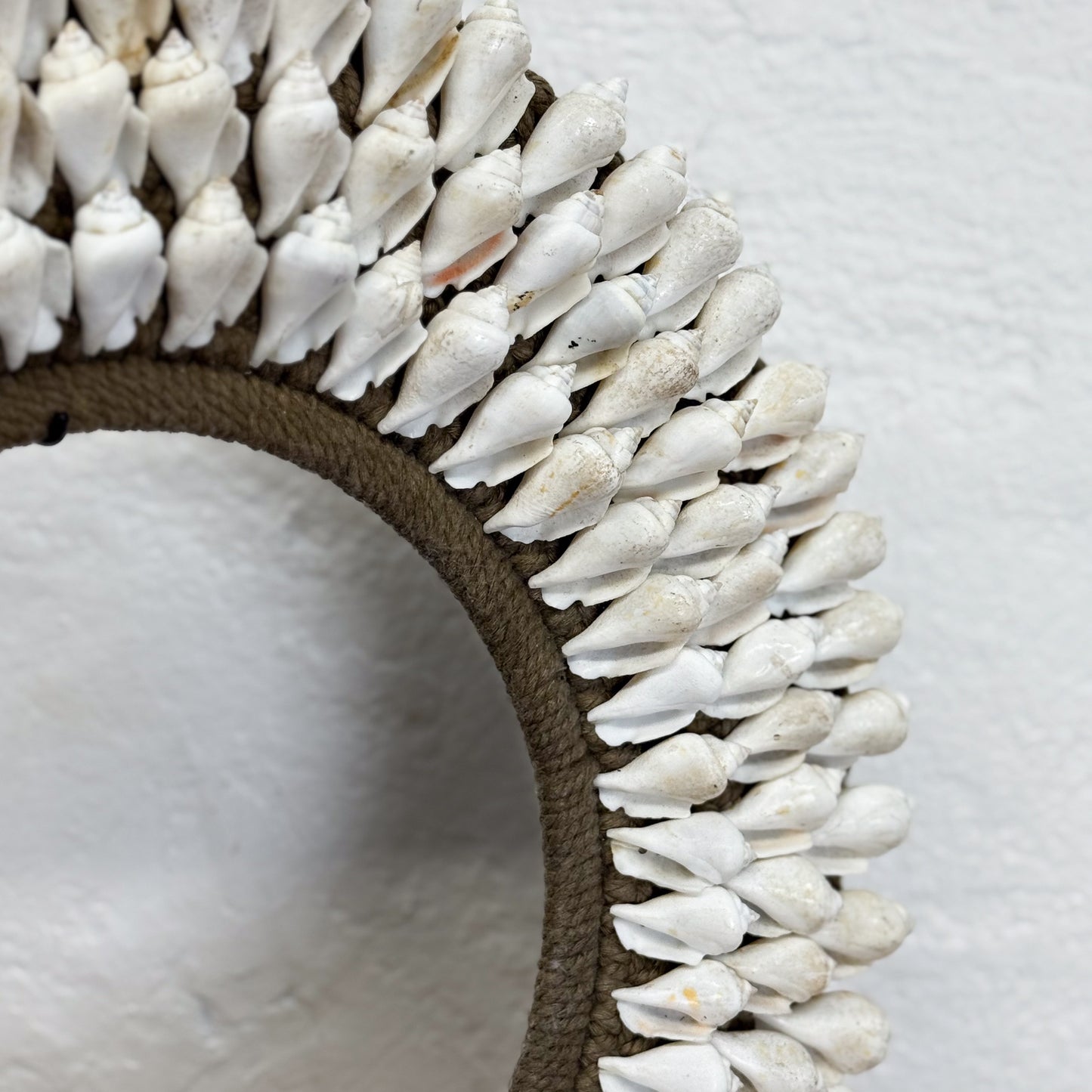 Decorative mirror with a shell border on a white background