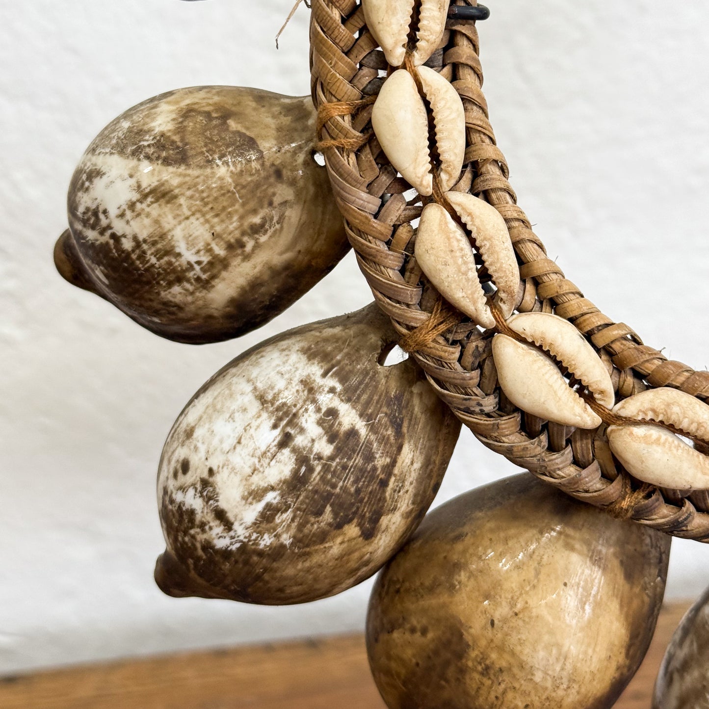 Decorative item with cowrie shells and wooden balls on a white background