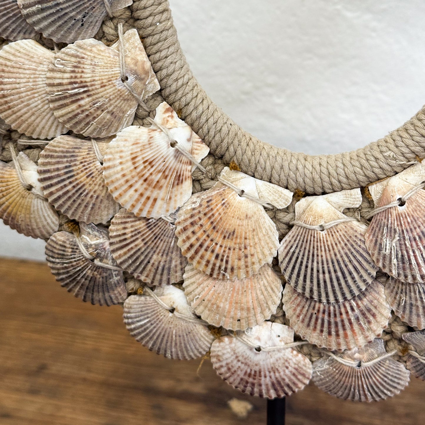 Decorative mirror with seashell pattern on a wooden surface