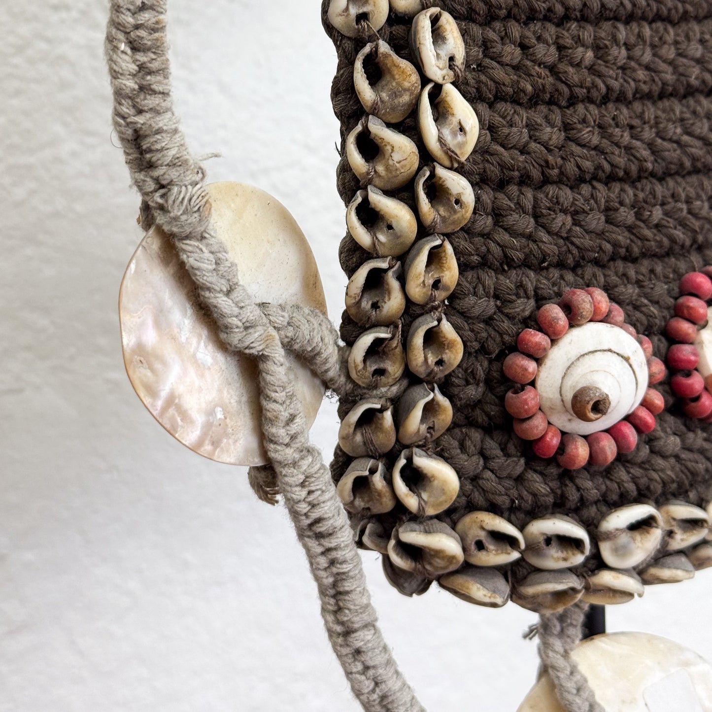 Decorative wall hanging with shell embellishments on a neutral background