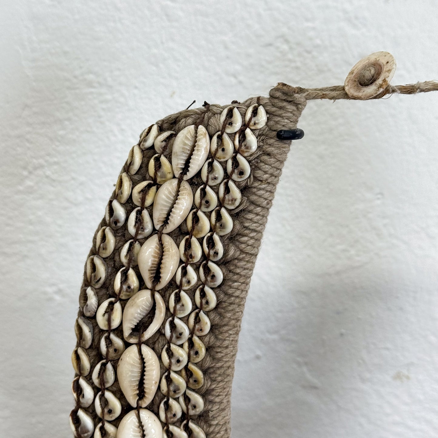 Decorative item with cowrie shells on a textured surface