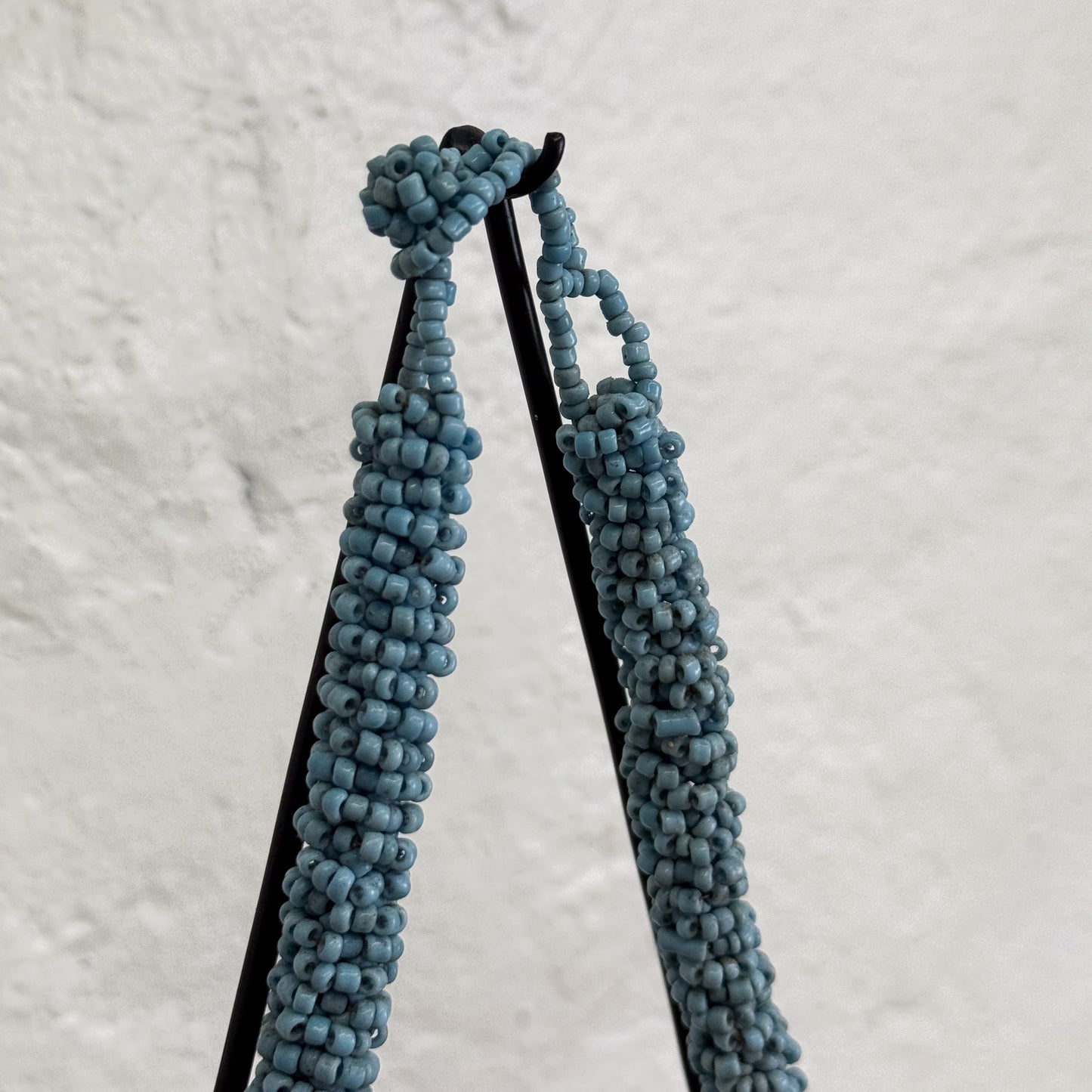 Pair of blue beaded earrings on a light gray background