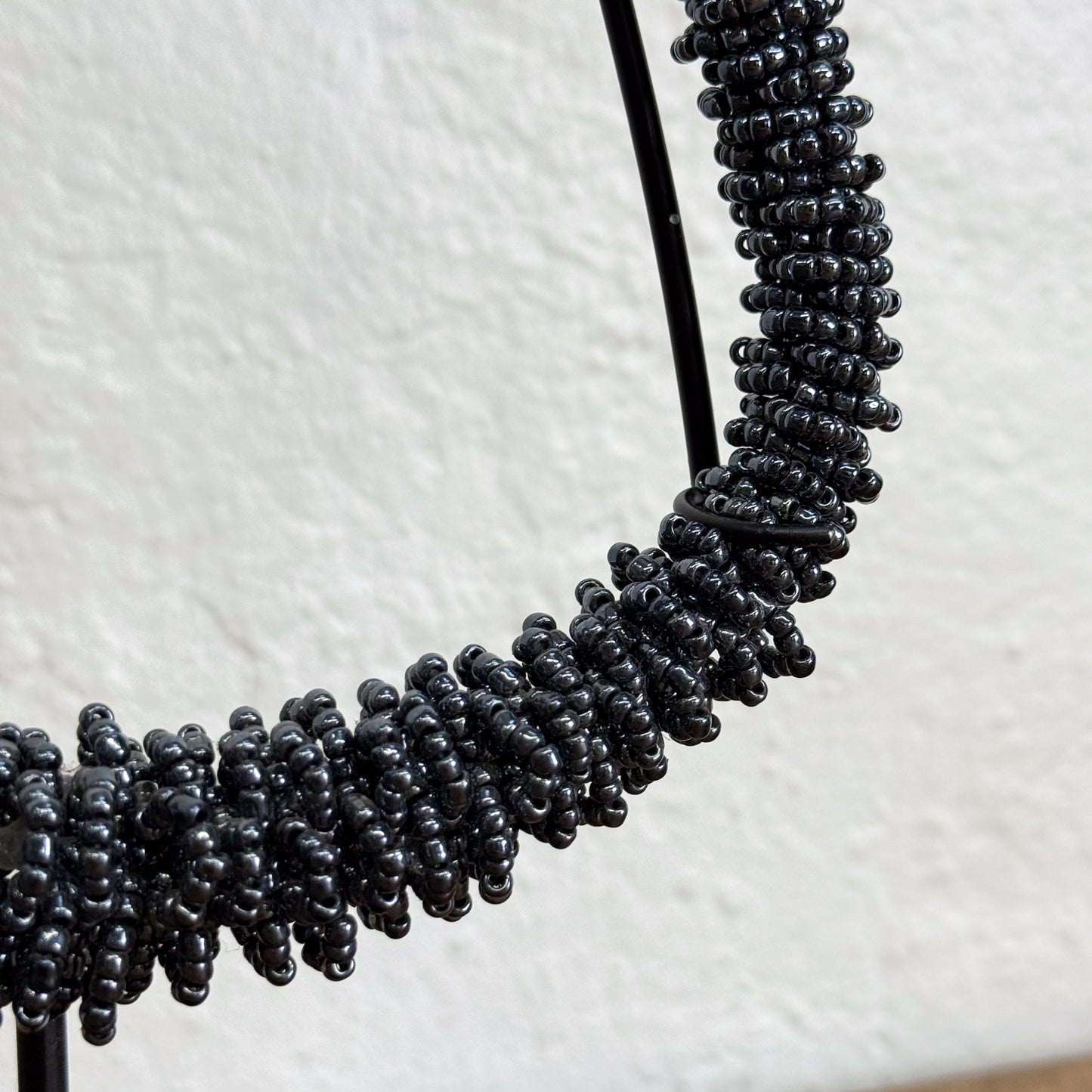 Close-up of a black beaded necklace on a white background