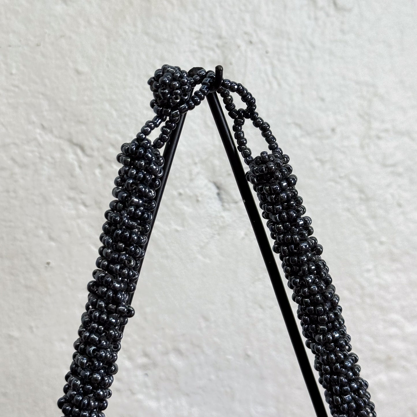 Black beaded earrings on a light gray background