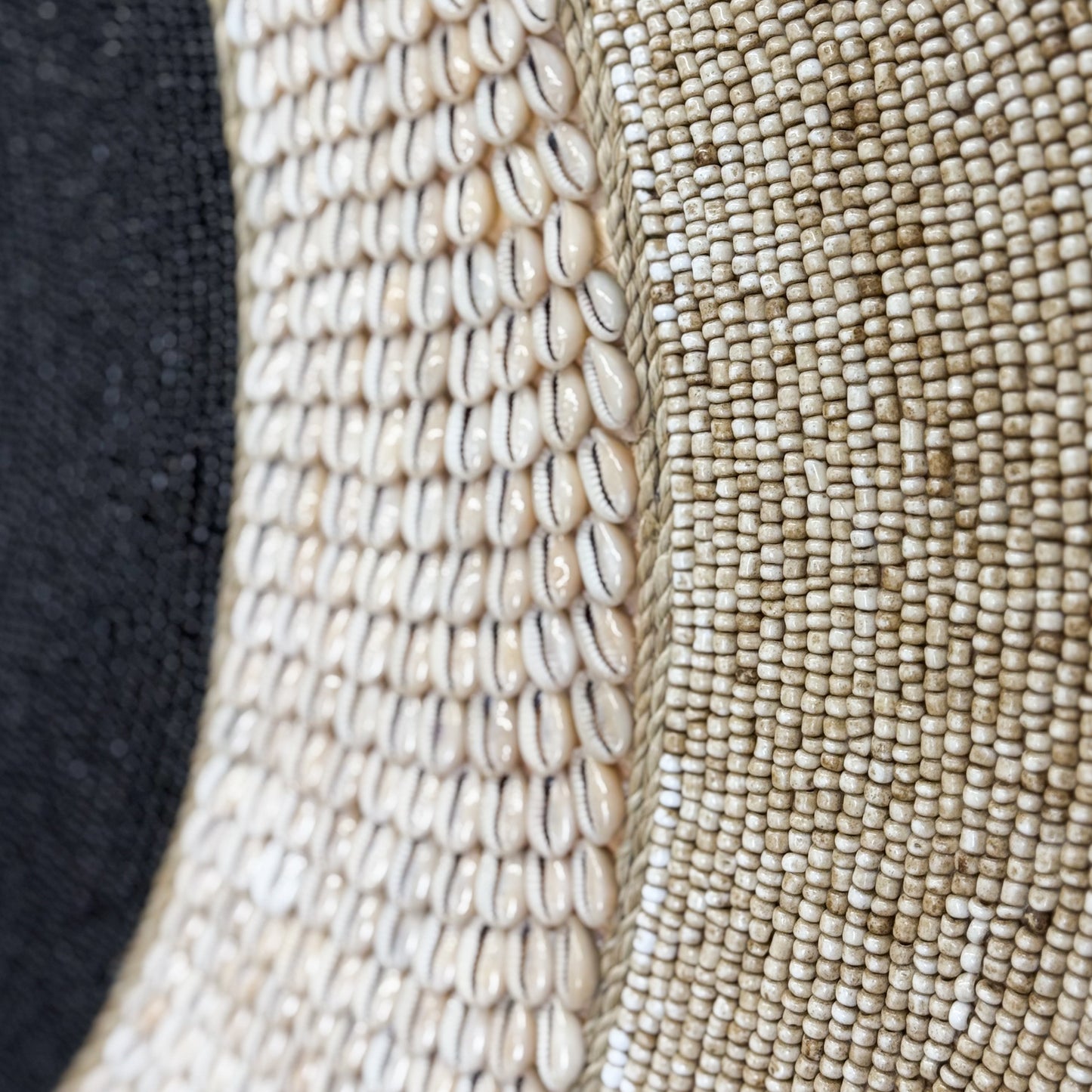 Close-up of a beaded fabric with a black background