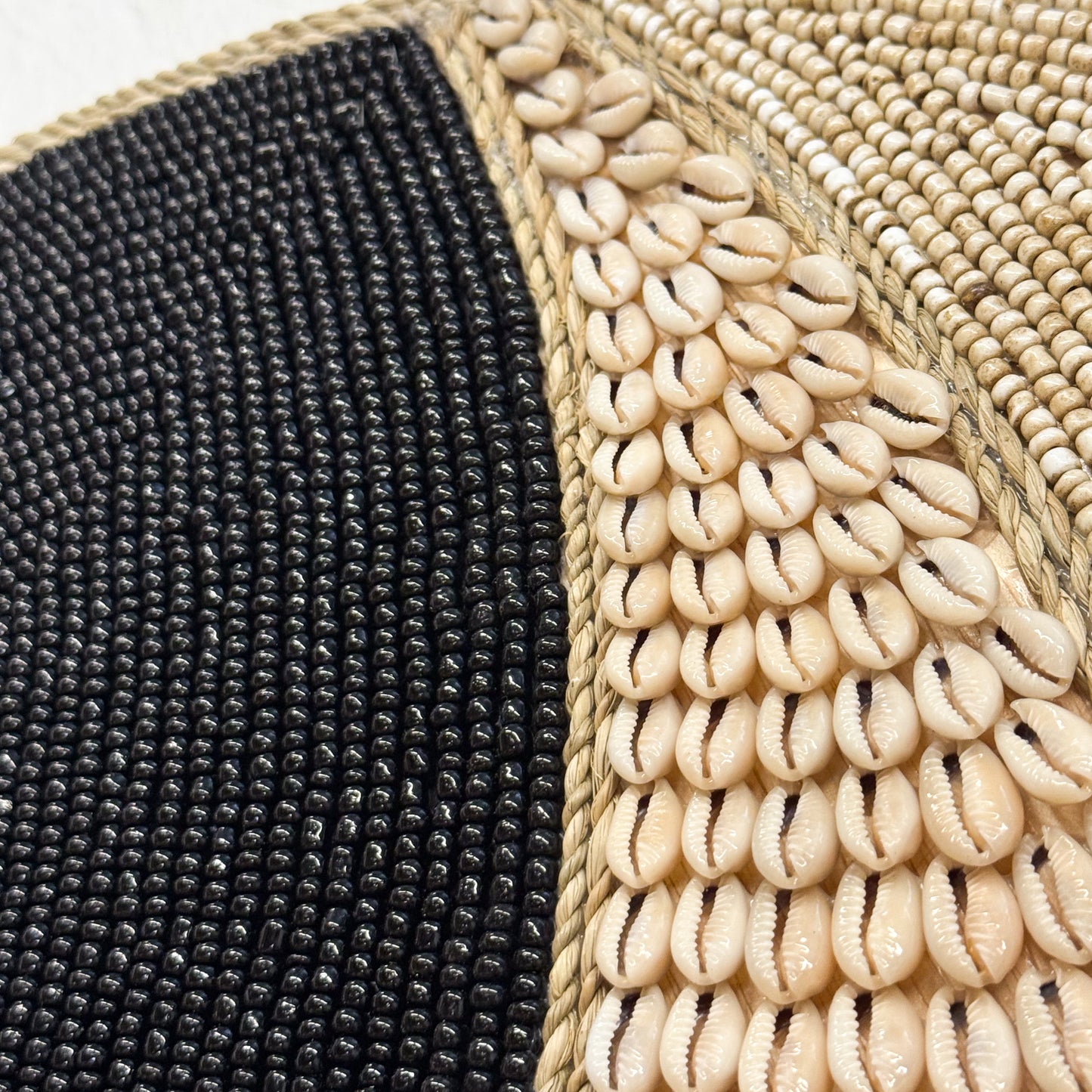 Close-up of a textured surface with black, beige, and woven patterns.