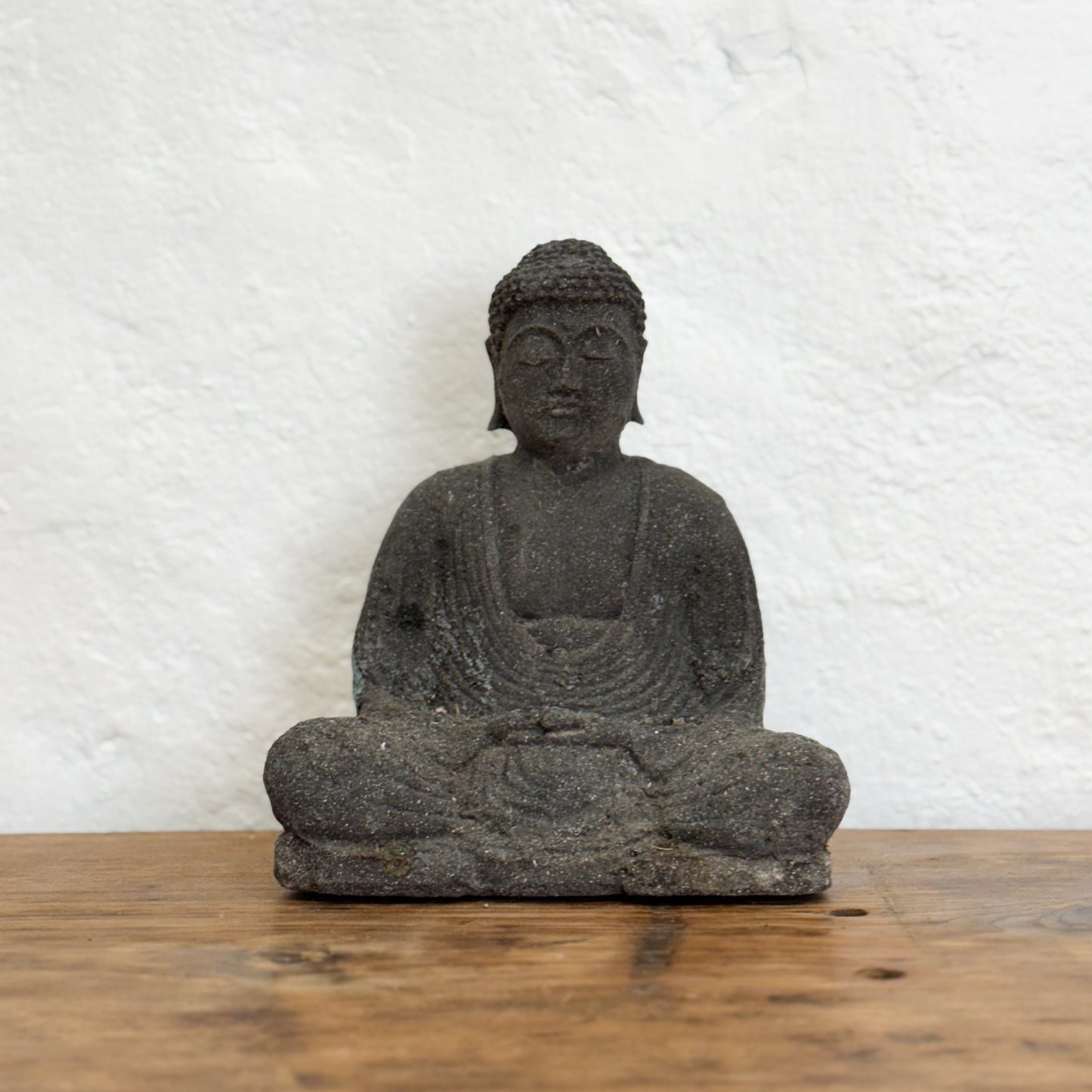 Stone Buddha statue on a wooden surface